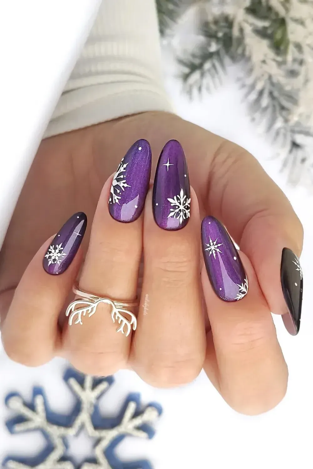 Purple Cat-Eye Nails with Snowflakes - Almond nails with a purple cat-eye effect and delicate hand-painted white snowflakes