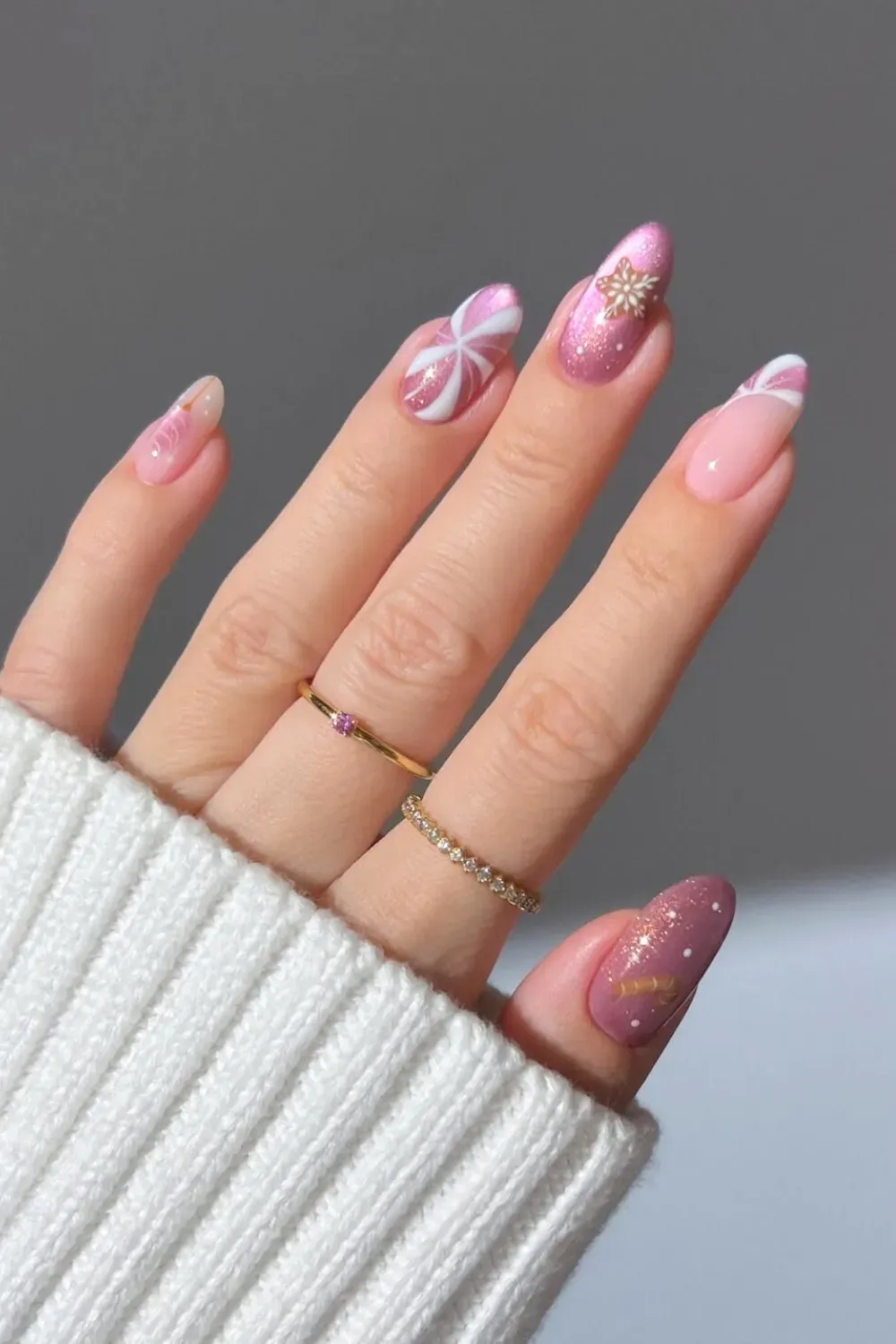 Pink Peppermint Swirl and Gingerbread Almond Nails - Almond nails with a pink peppermint swirl design, a cute gingerbread man, and a snowflak