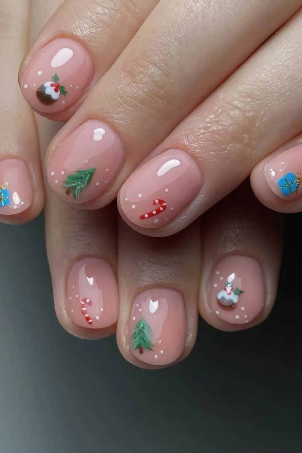 Sheer Pink Nails with Tiny Christmas Icons - Short oval nails with a sheer pink base and tiny hand-painted Christmas icons