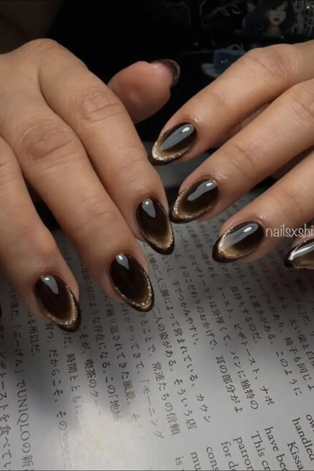 Two-Toned Brown Cat Eye French - Oval nails with a dark brown base featuring a crisp line of golden-brown cat eye magnetic polish applied along the French tip curve.