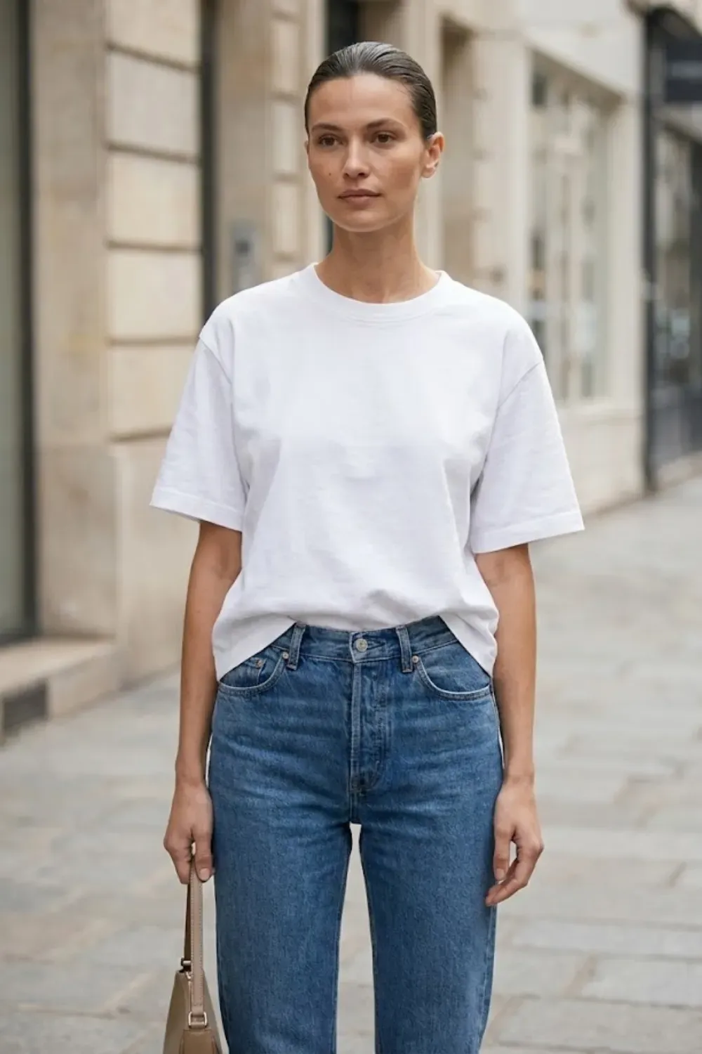 Woman wearing high-quality white cotton t-shirt and vintage jeans quiet luxury outfit detail.