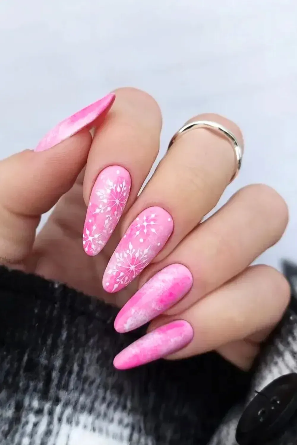 Glamorous Stiletto Snowflakes - Sharp stiletto nails covered in pink glitter with large white hand-painted snowflakes.