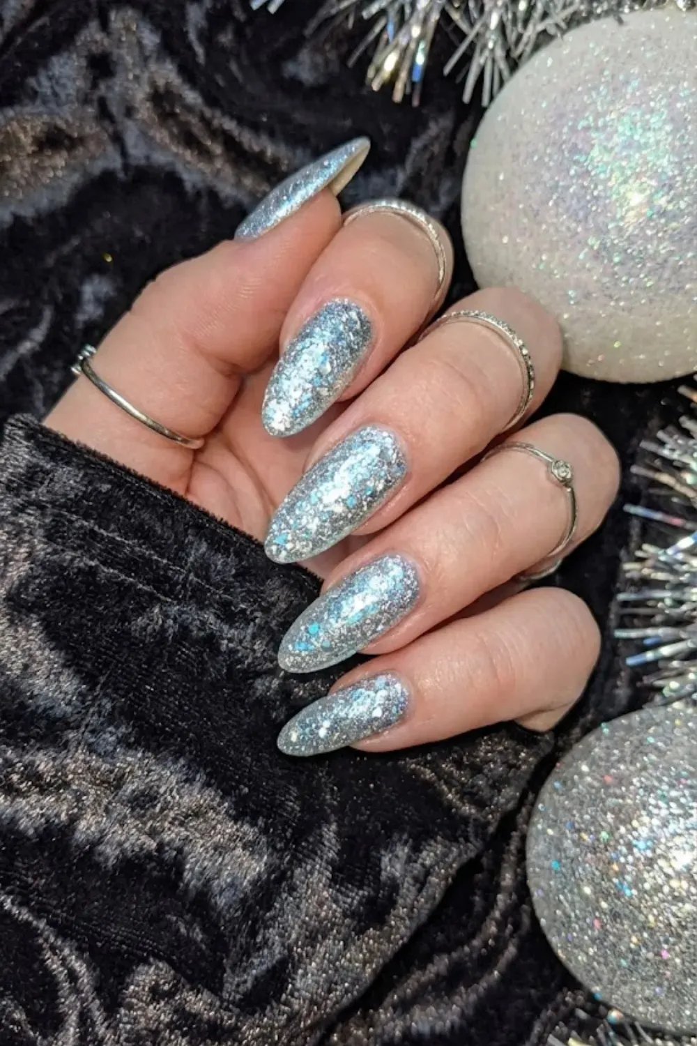 Holographic Silver Glitter Almond Nails - Full coverage sparkling silver holographic glitter on almond nails, perfect for New Year's Eve.