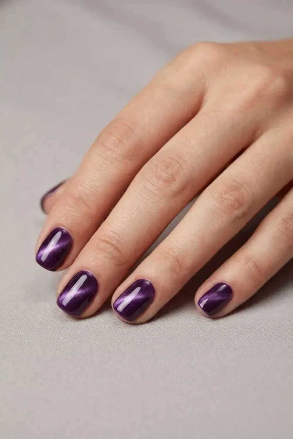 Short amethyst purple cat eye nails with jewel-tone magnetic shine