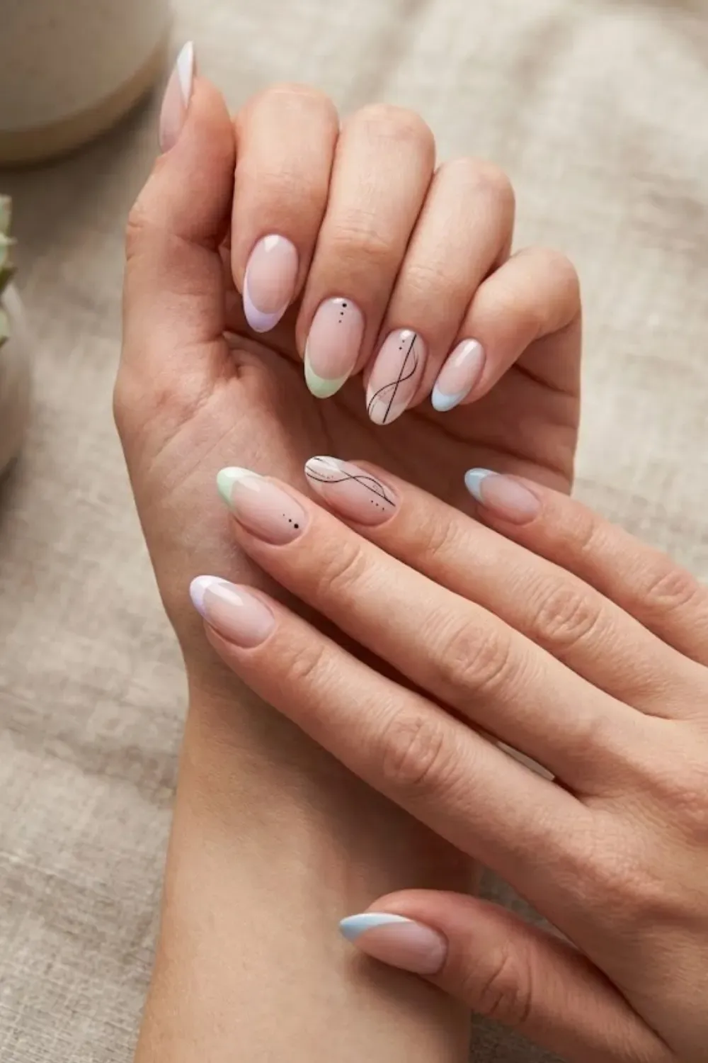 Abstract Pastel Tip Nail Art – Almond nails featuring abstract black fine lines and pastel french tips in mint, lavender, and baby blue.