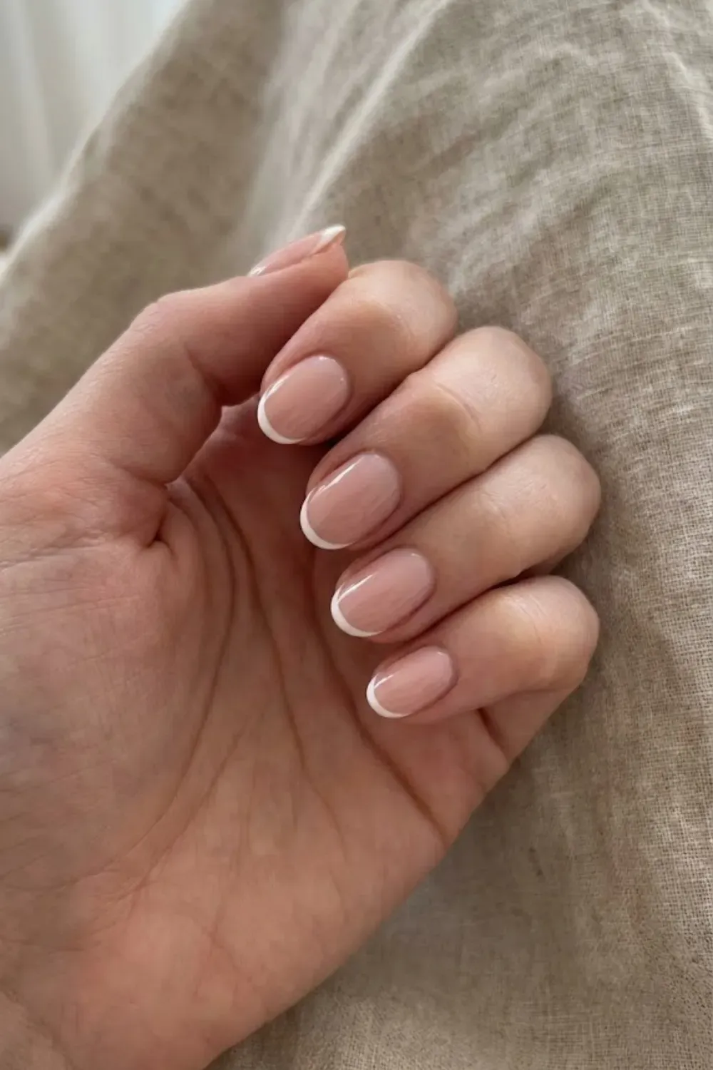 Classic White Micro French – Short squoval nails with a sheer nude base and crisp white micro french tips.