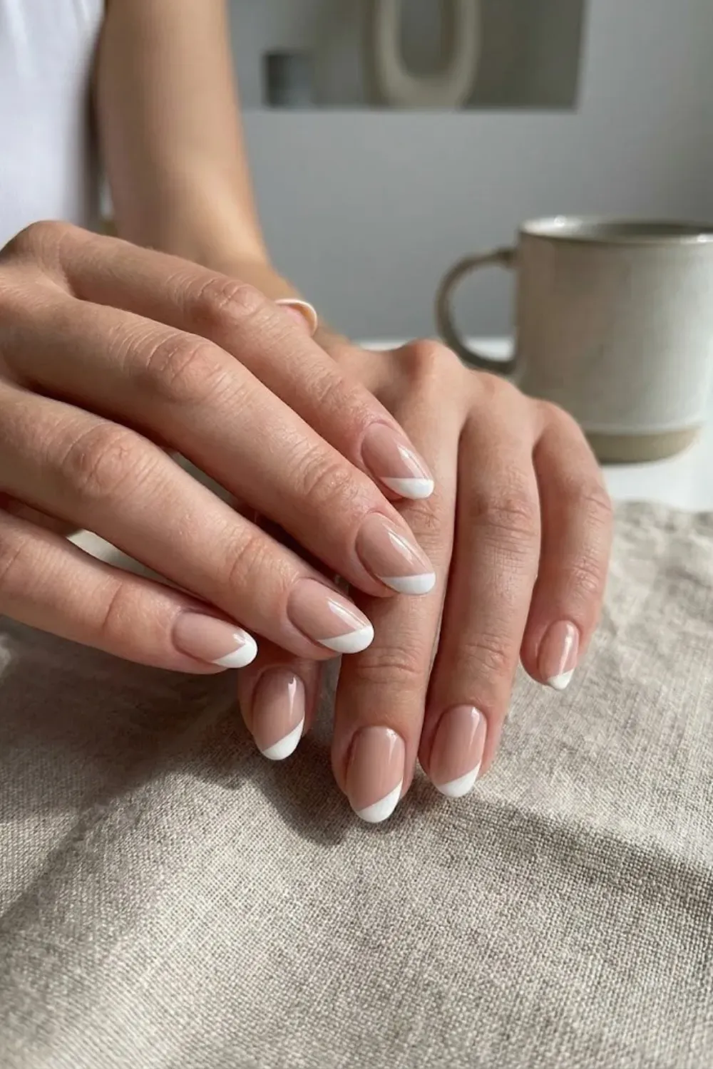 modern-diagonal-french-tip-nails - Modern diagonal French tip nail art on short nails, nude base with white tips.