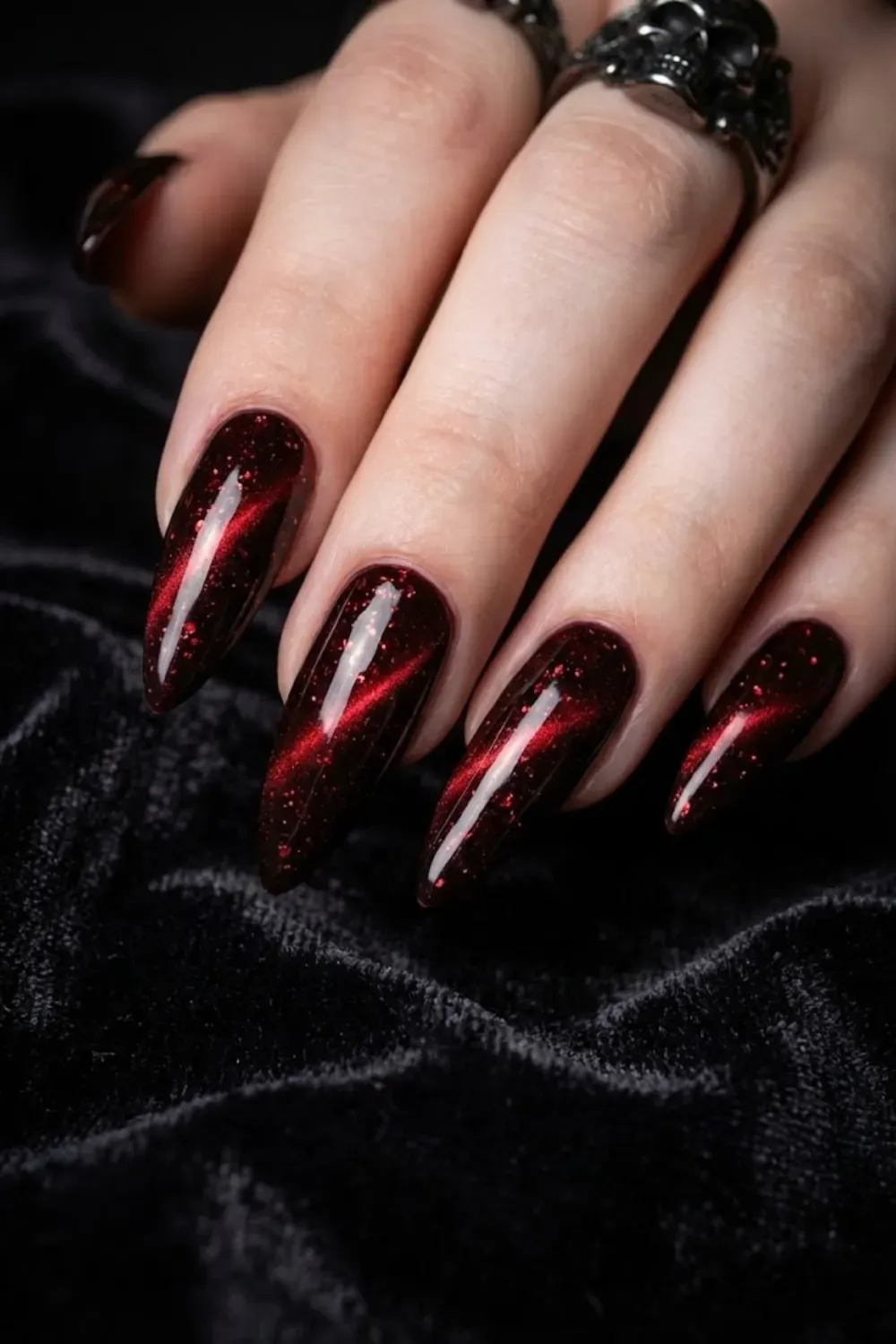 Dark vampy red and black cat eye nails with dramatic glitter finish