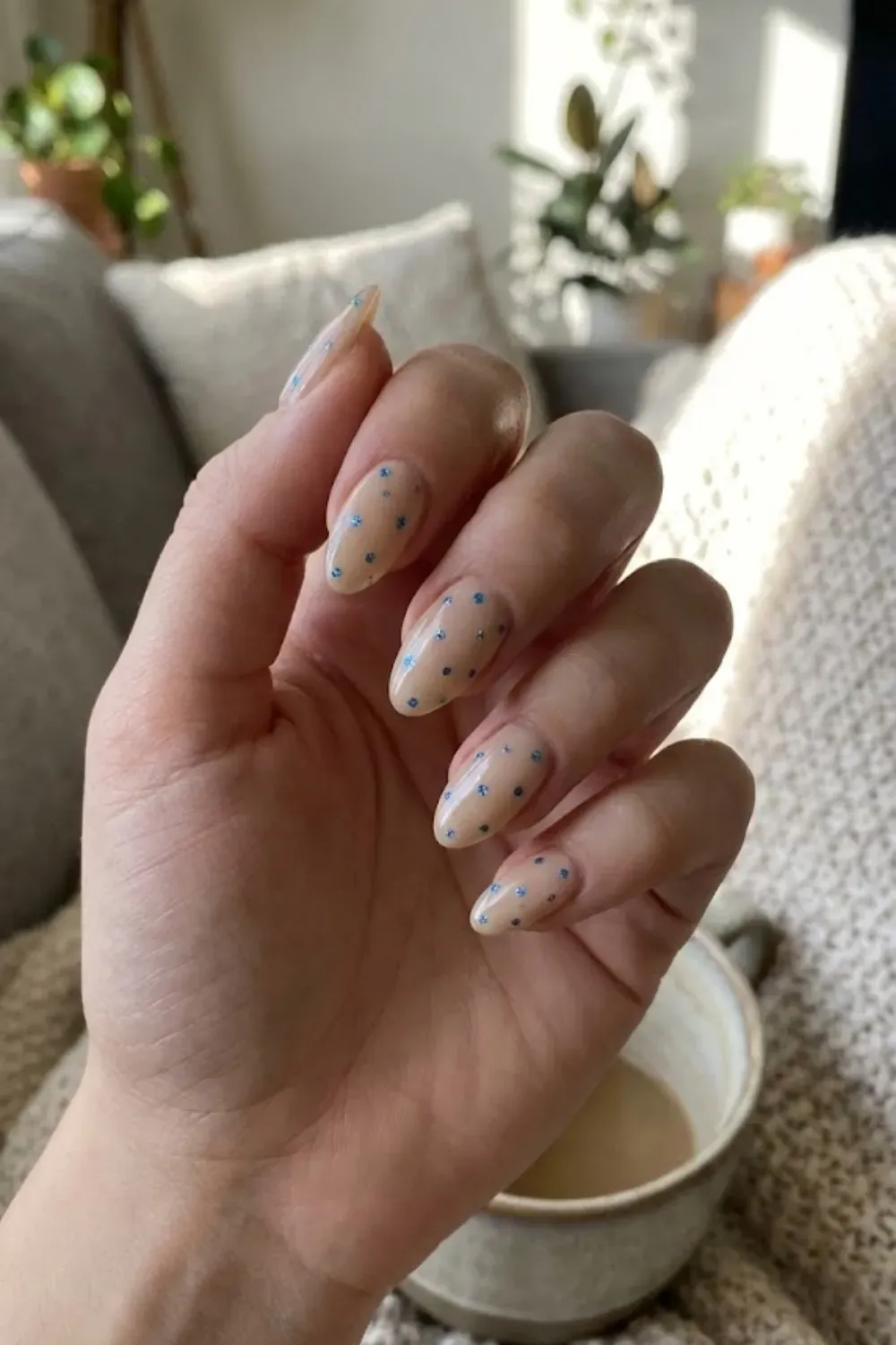 Minimalist Nude with Blue Floral Accents - almond sheer nude nails with tiny delicate blue glitter flower accents
