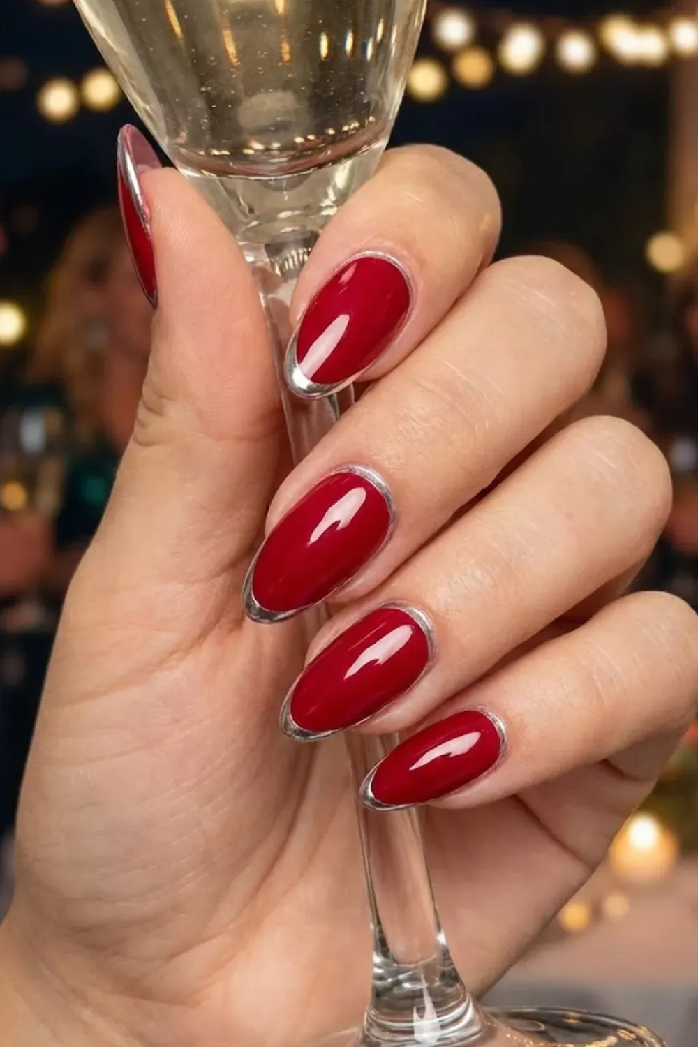 Red Nails with Chrome Outline – Almond nails in a classic red shade featuring a modern silver chrome outline along the cuticles and tips.