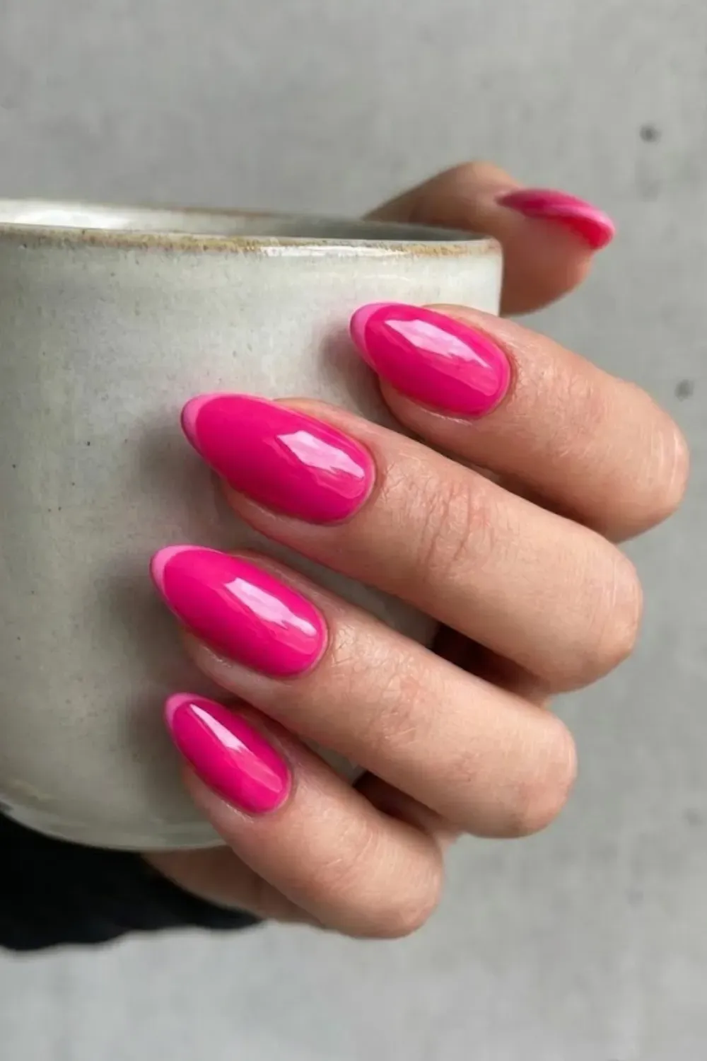 Hot Pink Two-Tone French Nails – Oval nails featuring a hot pink base with a lighter pink french tip design.