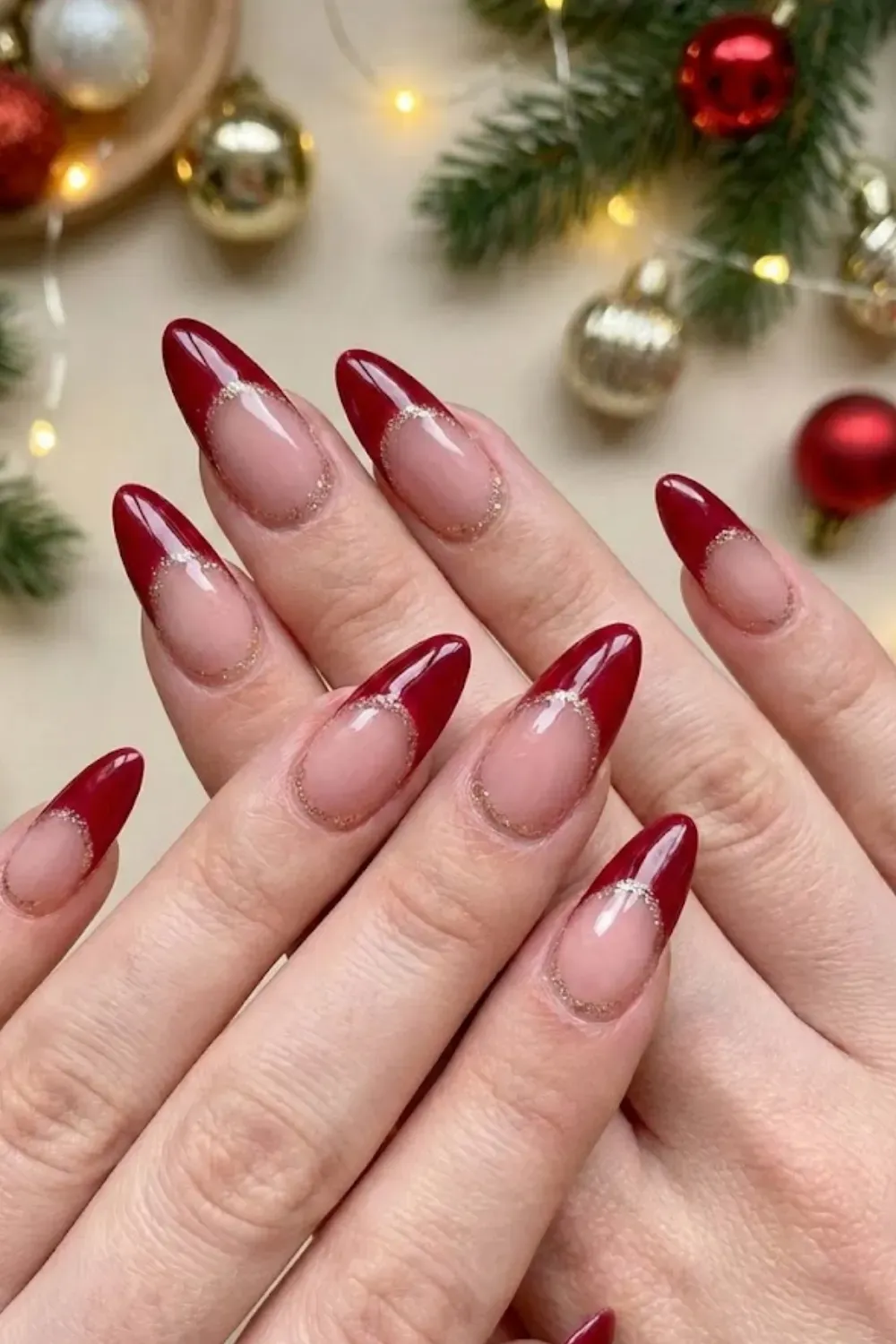 .Red Glitter Cuff Nails — long almond nails with deep red tips outlined by a gold glitter cuff line