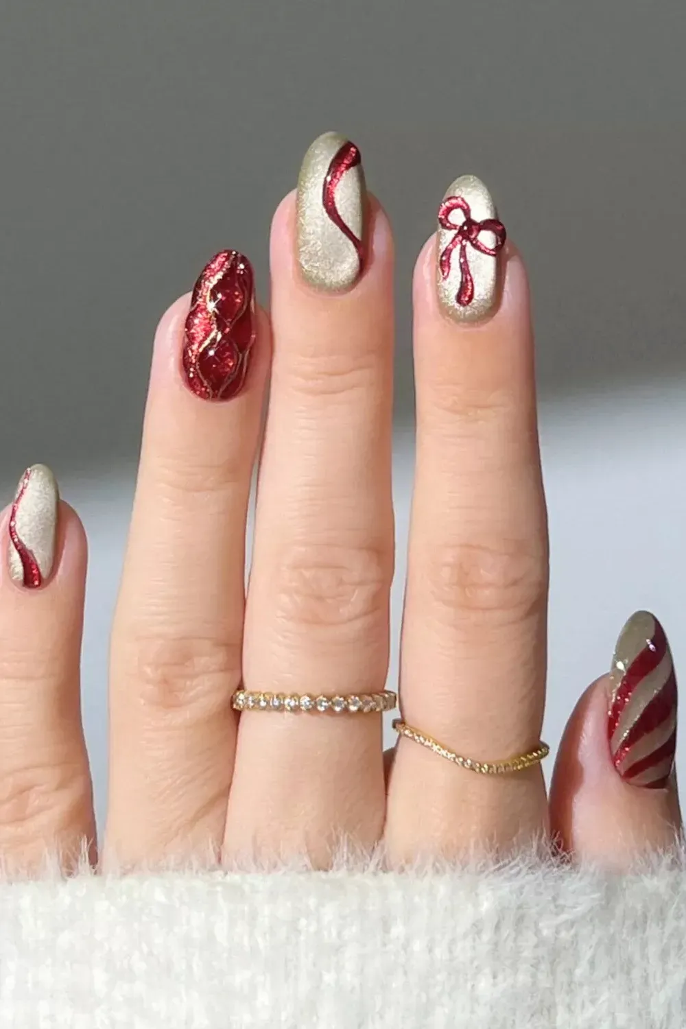 Gold Shimmer with Textured Red Bows - Gold metallic nails featuring 3D textured red glitter ribbons and swirls.