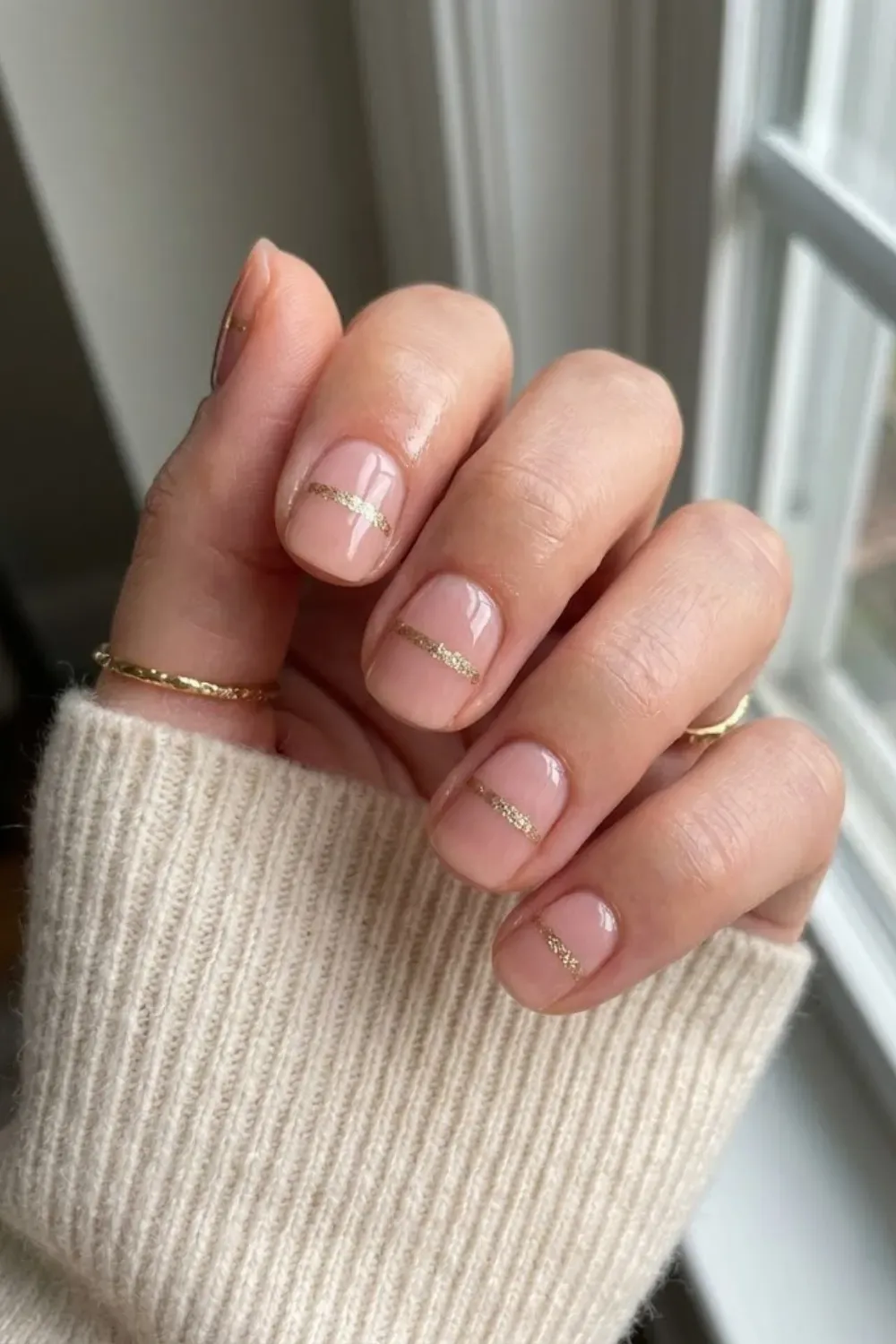 Nude with Horizontal Gold Glitter Band - Short pink-nude nails featuring a thin, precise horizontal band of gold glitter across the middle of the nail.