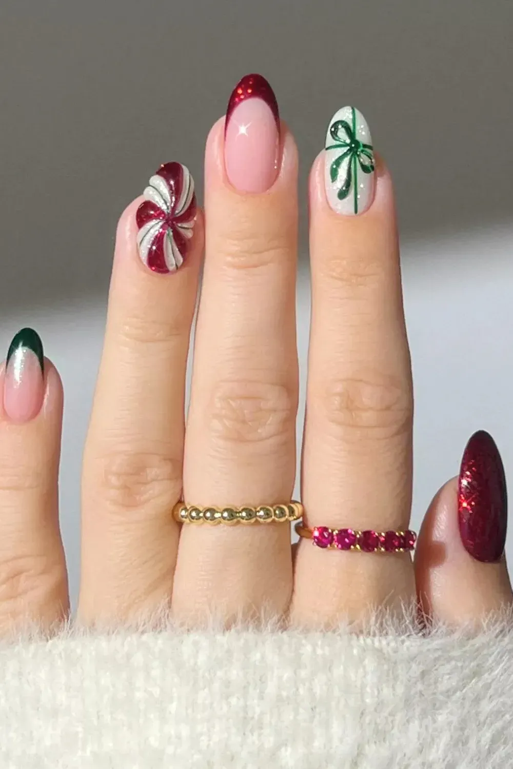 Mismatched Red and Green Holiday Nails - Mix and match nails featuring red french, green bows, and peppermint swirl designs.