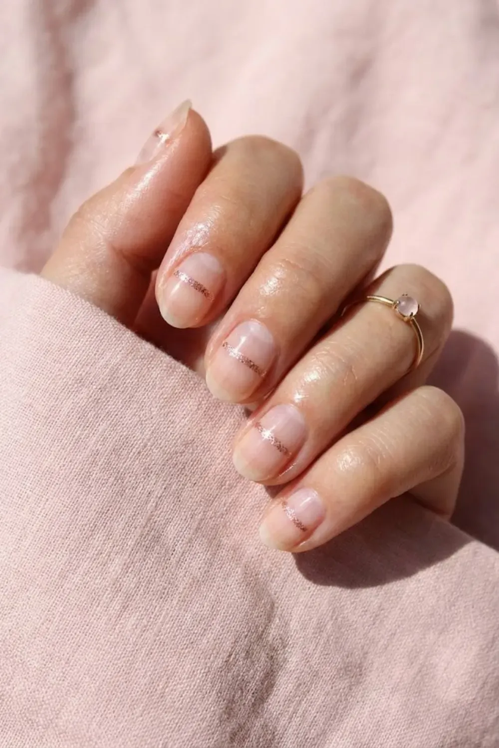 Natural with Rose Gold Glitter Band - Short natural nails with a delicate horizontal stripe of rose gold glitter, offering a feminine minimalist look.