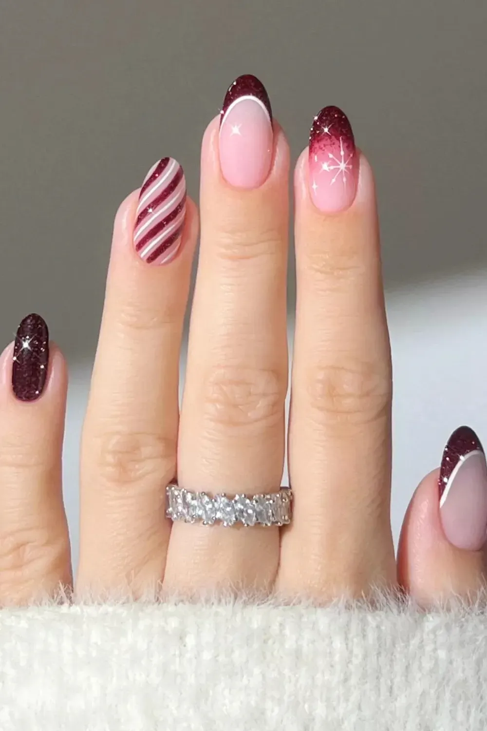 Burgundy Snowflake and Stripe Nails - Deep red burgundy nails mixing french tips, snowflakes, and diagonal stripes.