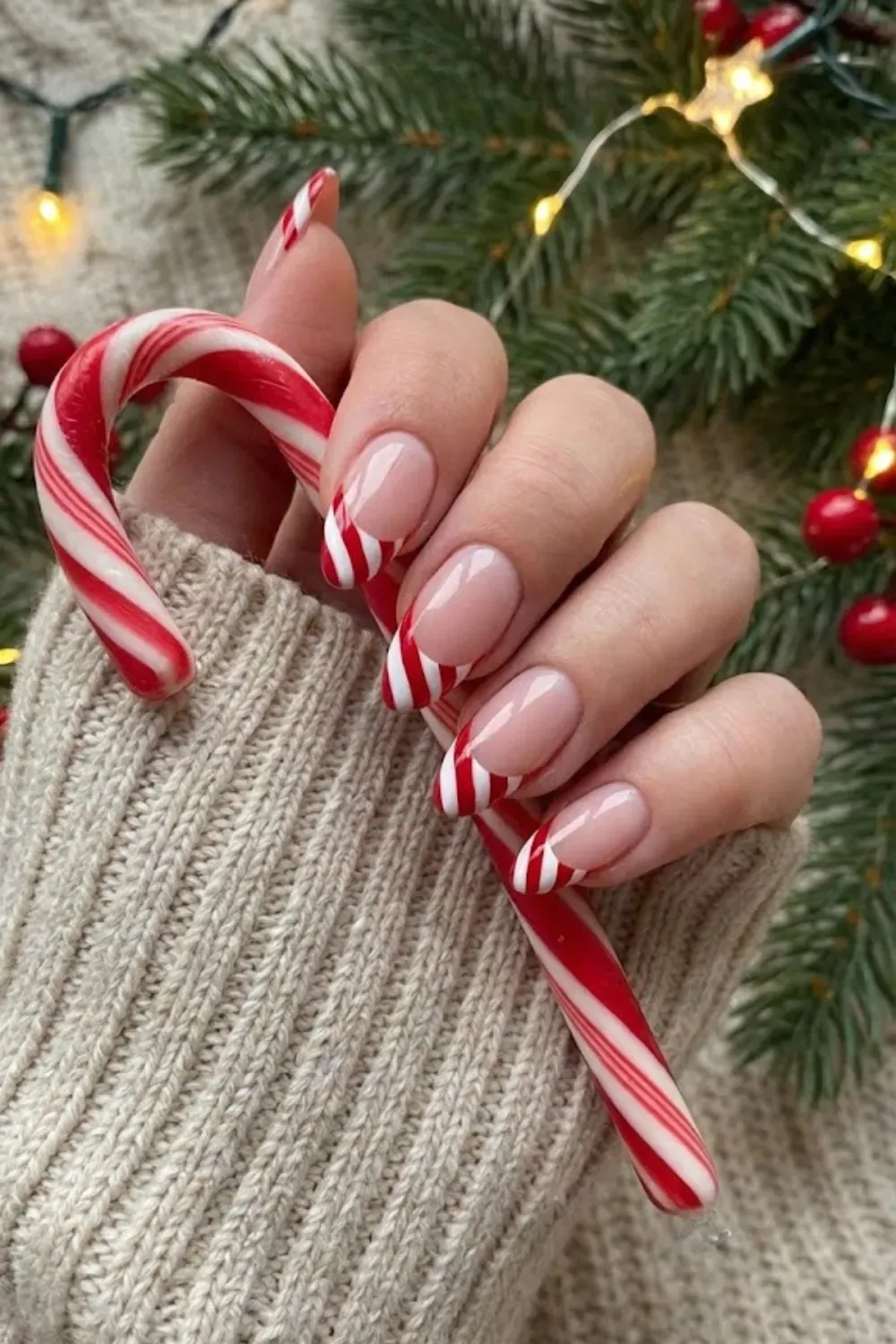 Candy Cane Striped French Tip Nails - Nude almond nails featuring playful red and white candy cane striped French tips.
