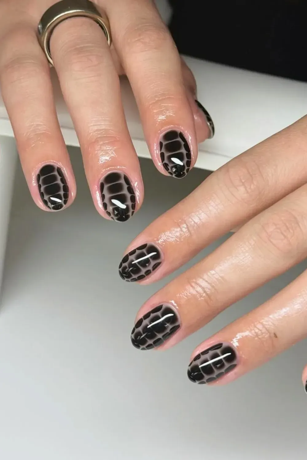 Black Croc Print on Nude	Short oval nails with glossy black crocodile pattern on nude