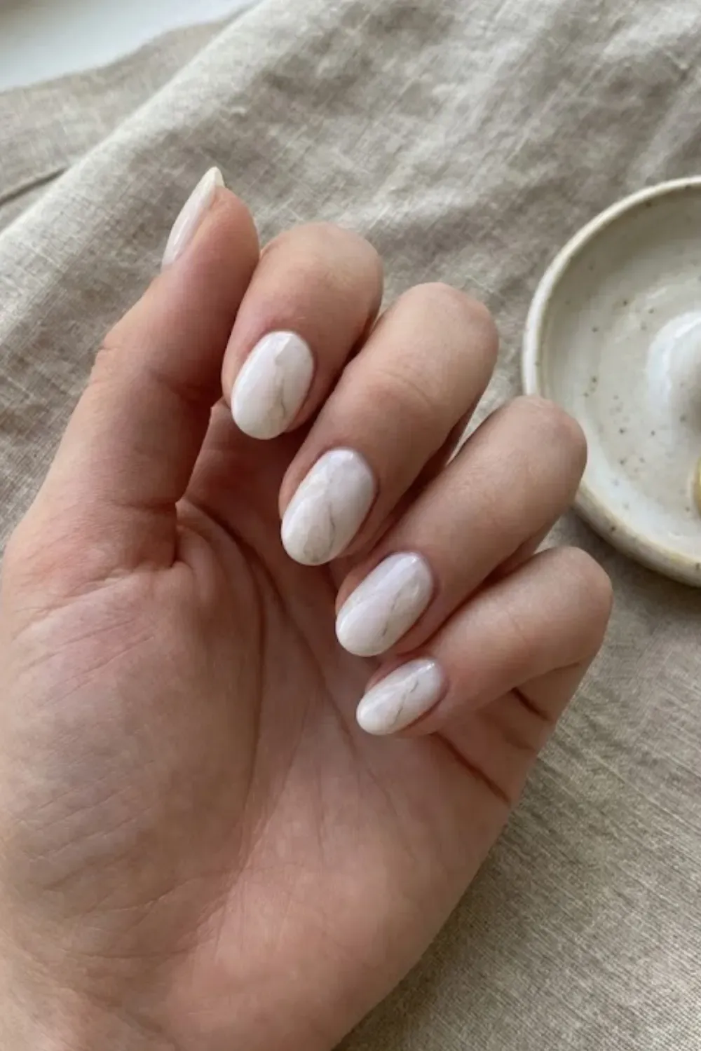 Milky White Marble Quartz – Oval nails featuring a soft milky white base with delicate grey marble stone effects.