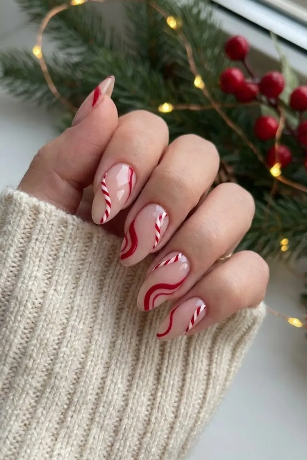 Abstract Red Swirls and Candy Cane Nails - Modern nude nails with abstract red swirls and festive candy cane striping art.
