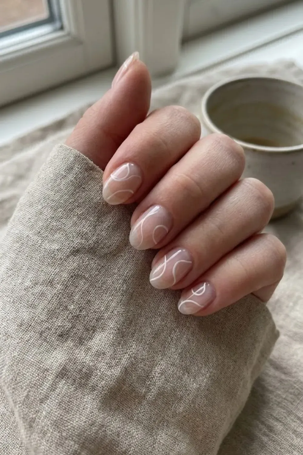 Abstract White Swirls – Sheer oval nails featuring minimalist white abstract swirl line art.