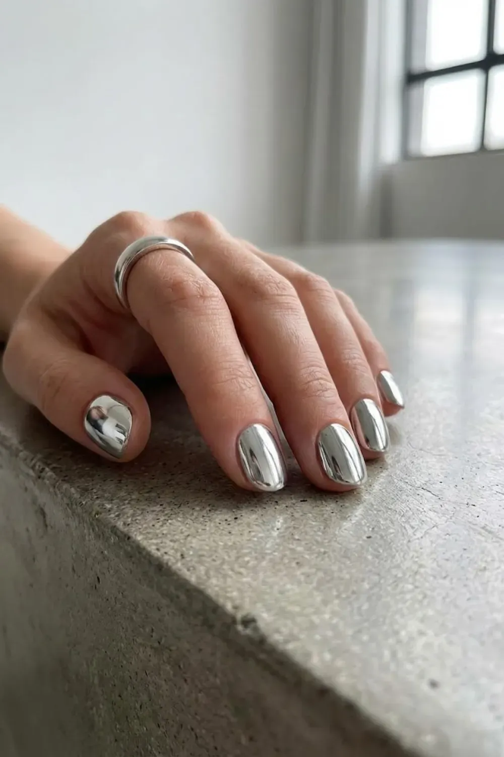 Liquid Silver Chrome Round - Short round nails covered in a bold, reflective liquid silver chrome powder for a futuristic minimalist style.