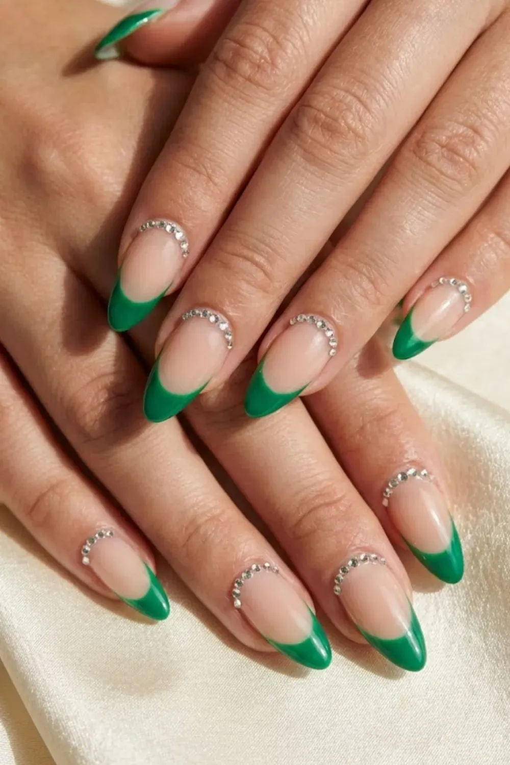 Emerald Rhinestone Cuff Nails — almond nails with green French tips outlined by a sparkling rhinestone cuff.