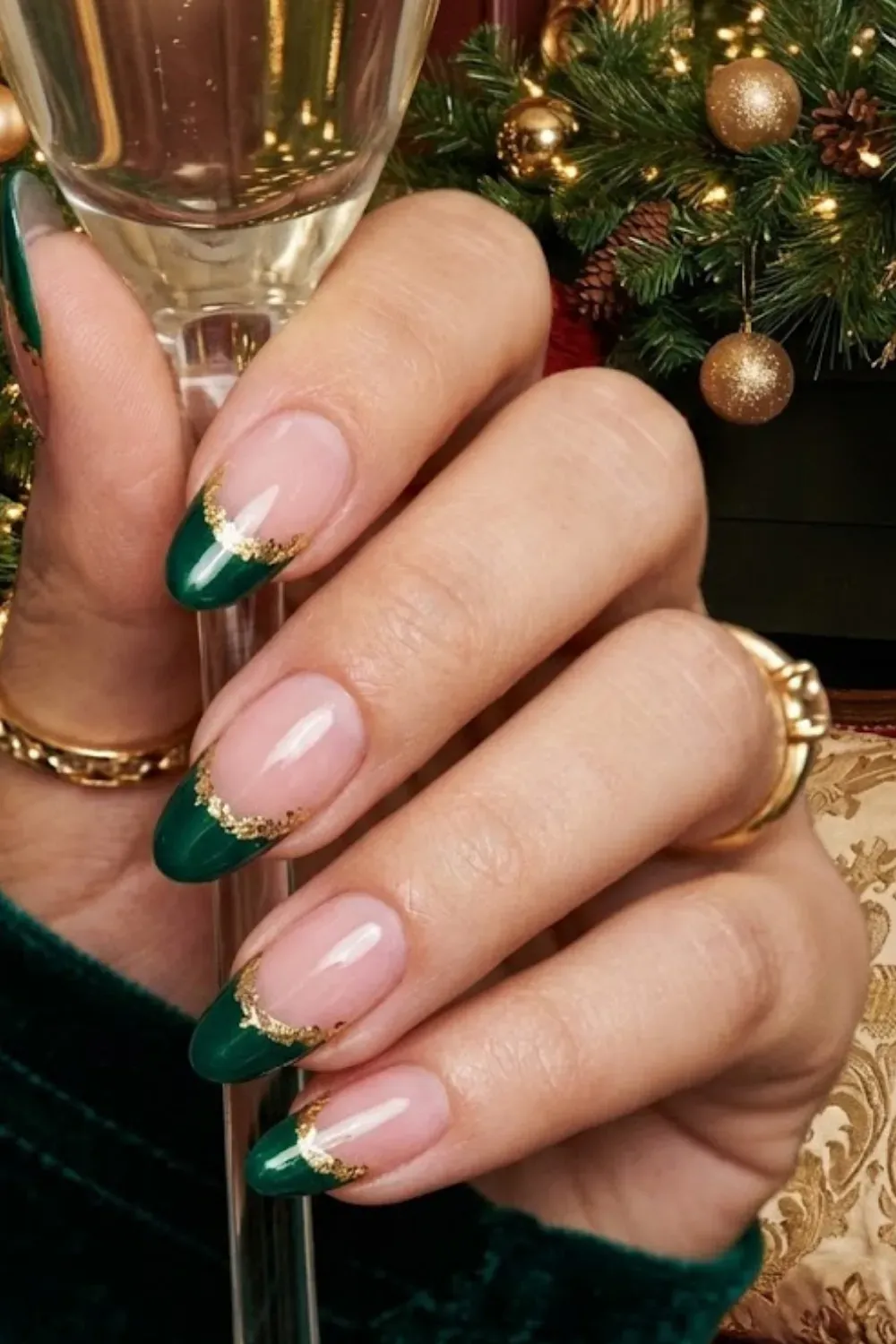 Green Gold Foil Nails — asymmetrical deep green French tips outlined with gold foil flakes on oval nails.