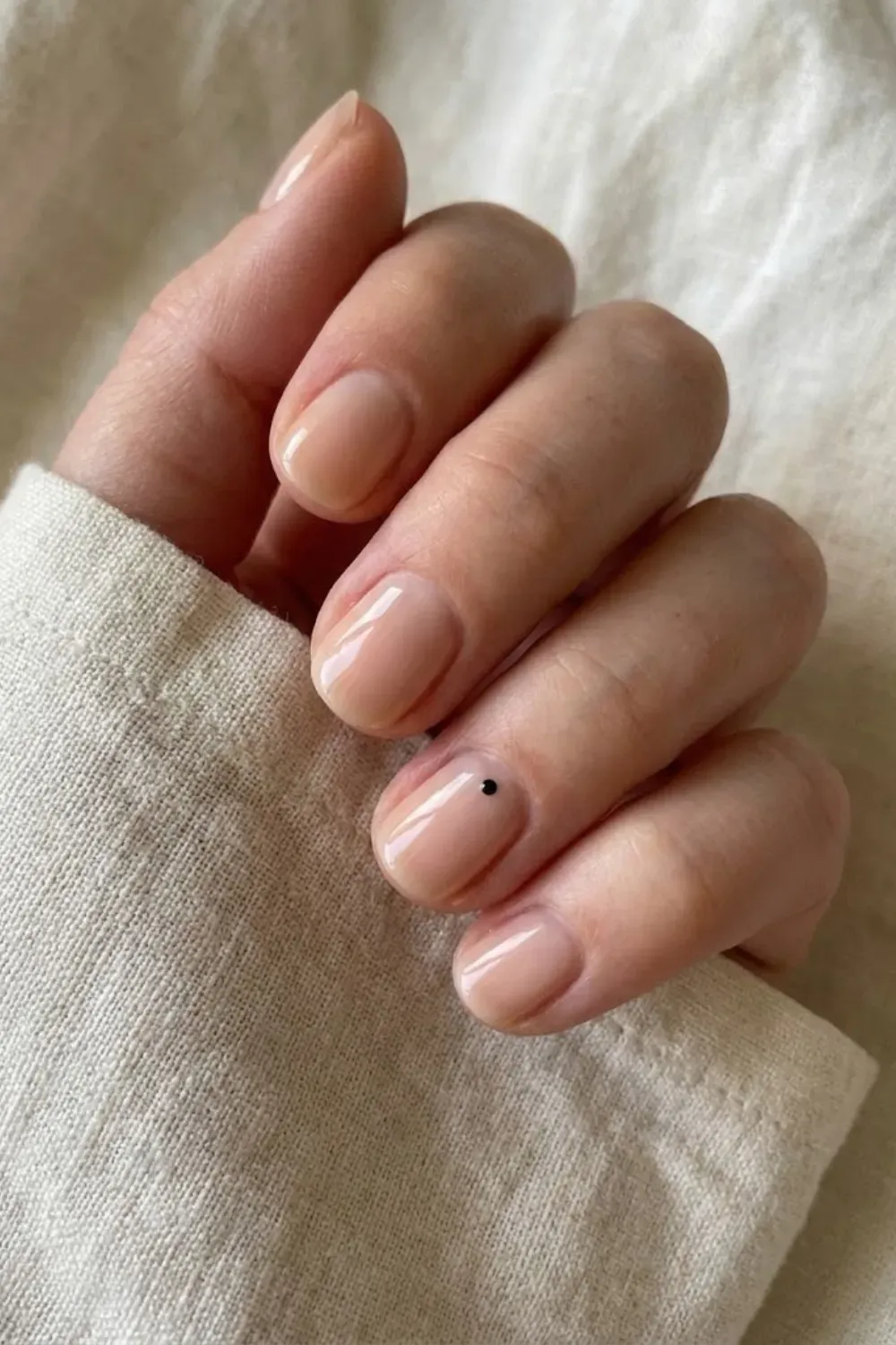 Minimalist Black Dot Accent - Short sheer nude nails accented with a single, tiny minimal black dot placed near the cuticle.