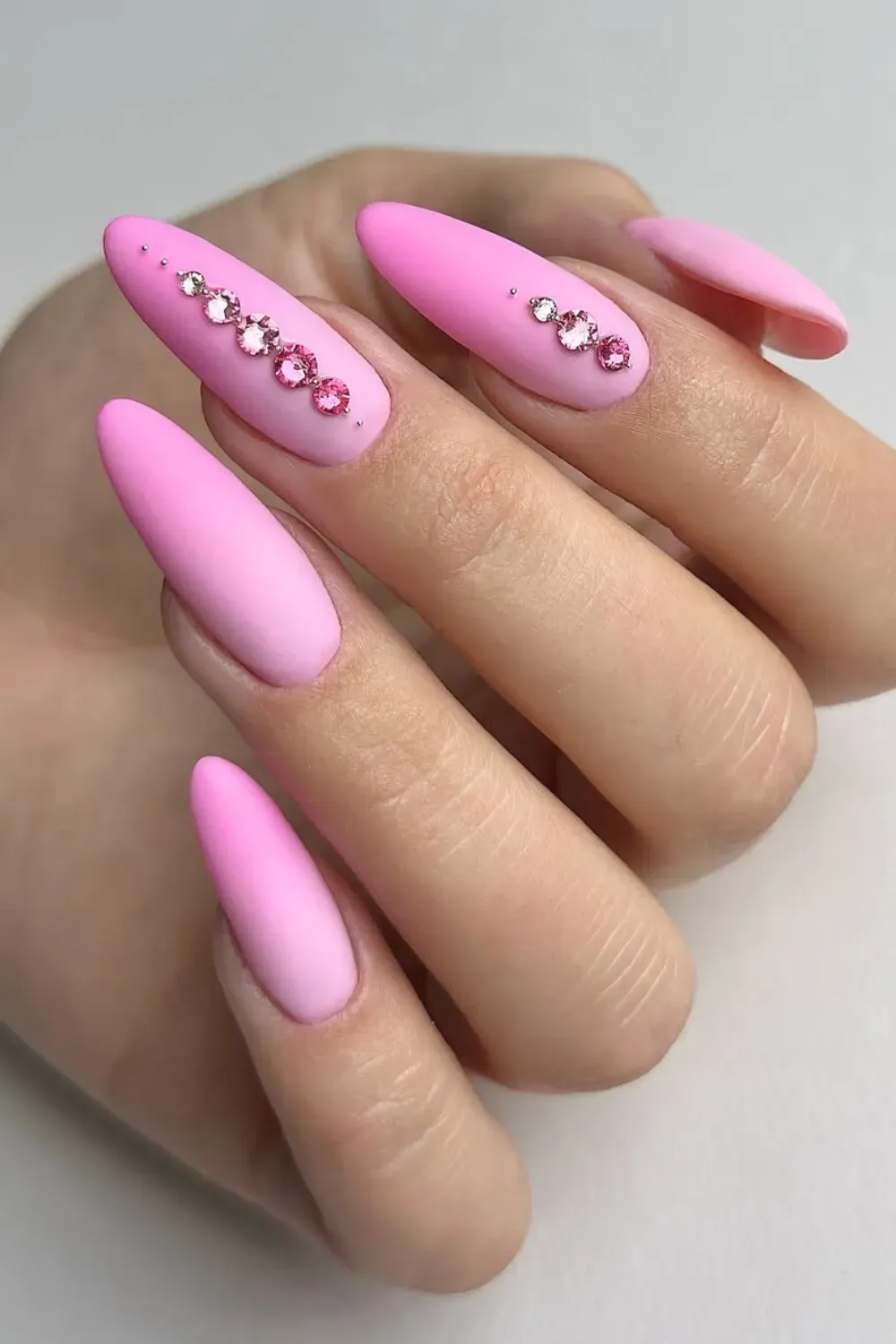 Matte Pink & Rhinestones - Matte bubblegum pink almond nails decorated with a line of pink rhinestones.