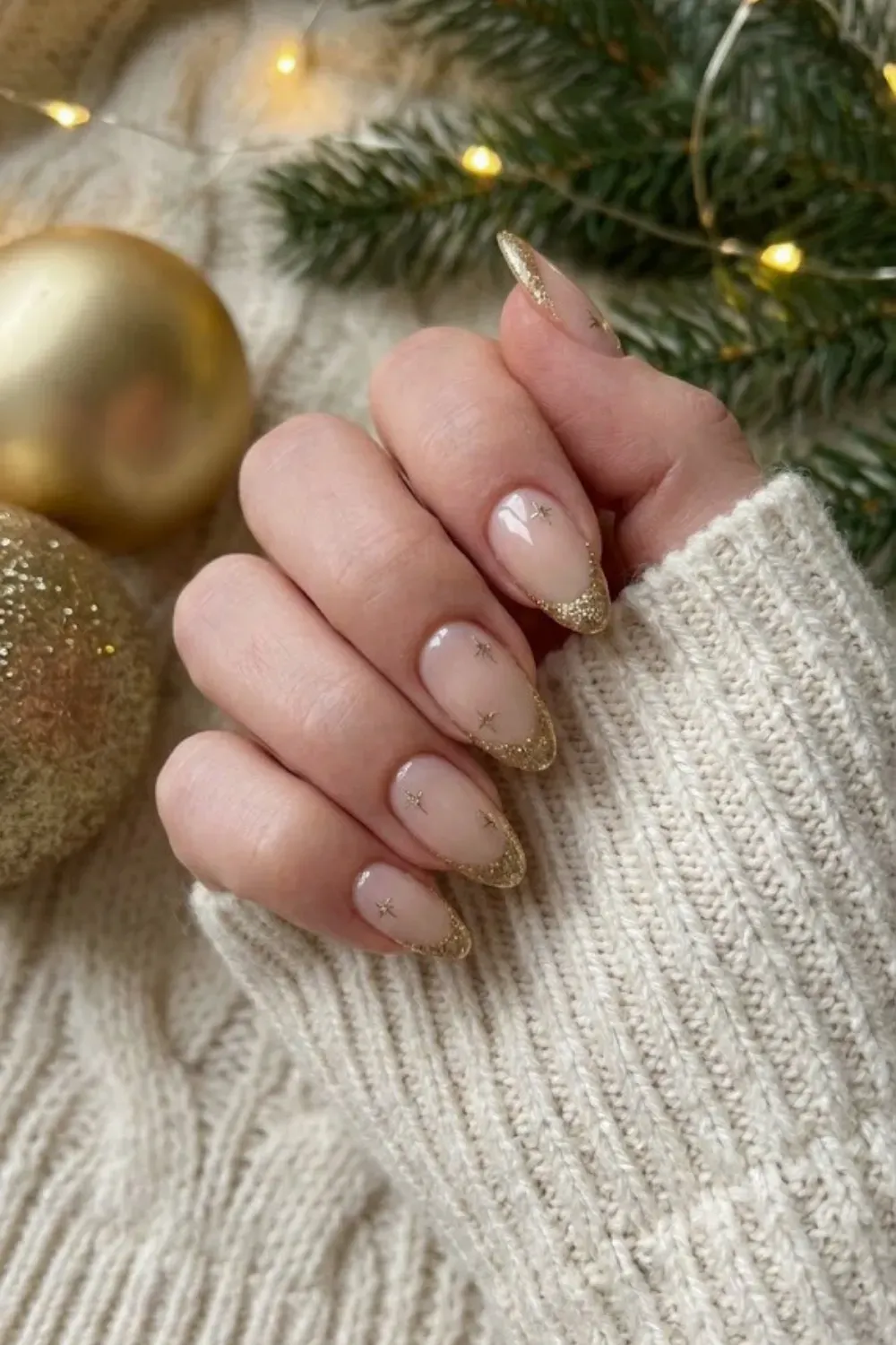 Nude Nails with Gold Glitter French Tips - Classic nude almond nails finished with sparkling gold glitter French tips and star accents