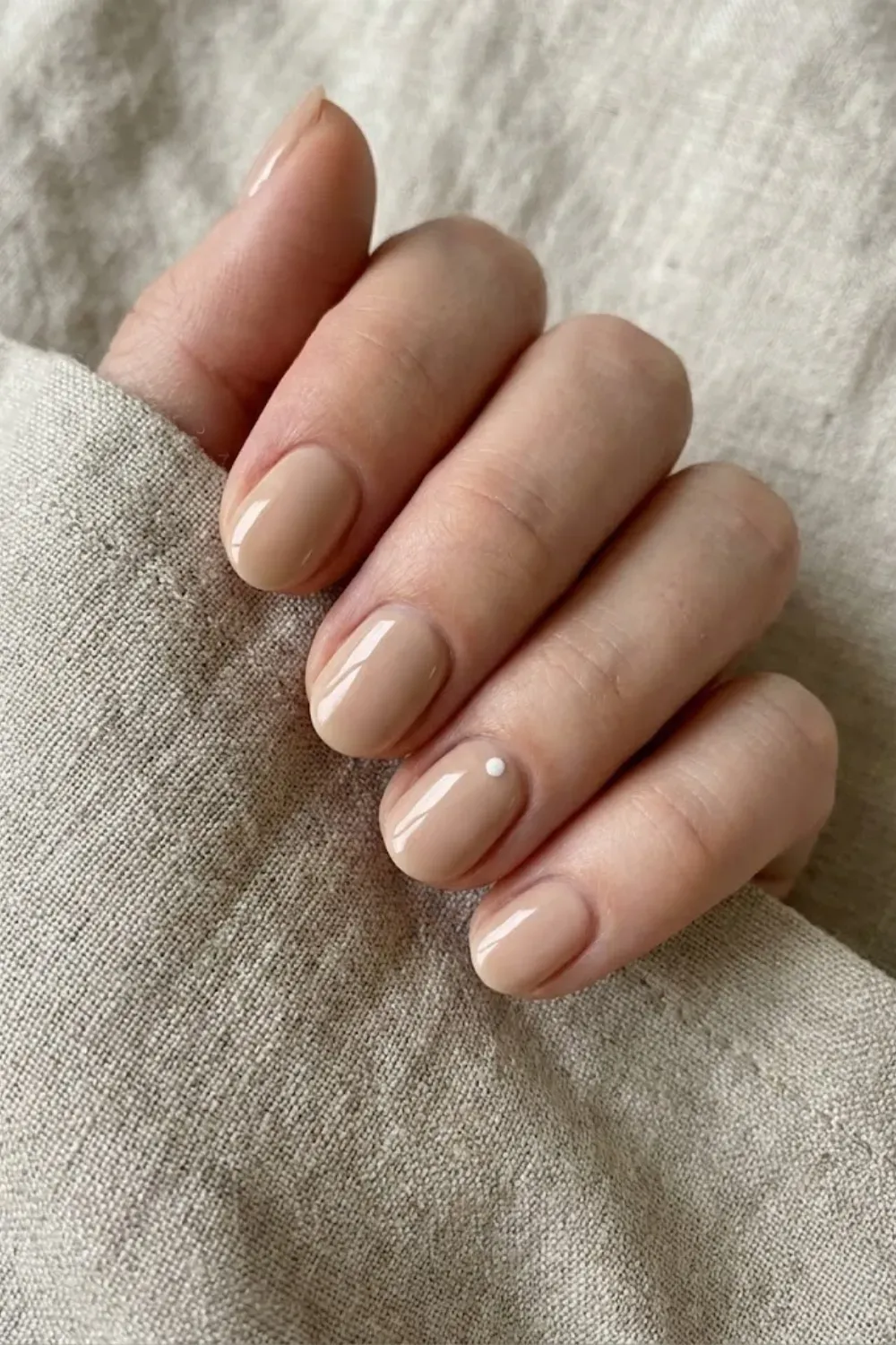 Nude with White Micro-Dot - Short beige nails featuring a subtle minimalist white dot design at the base of the nail.