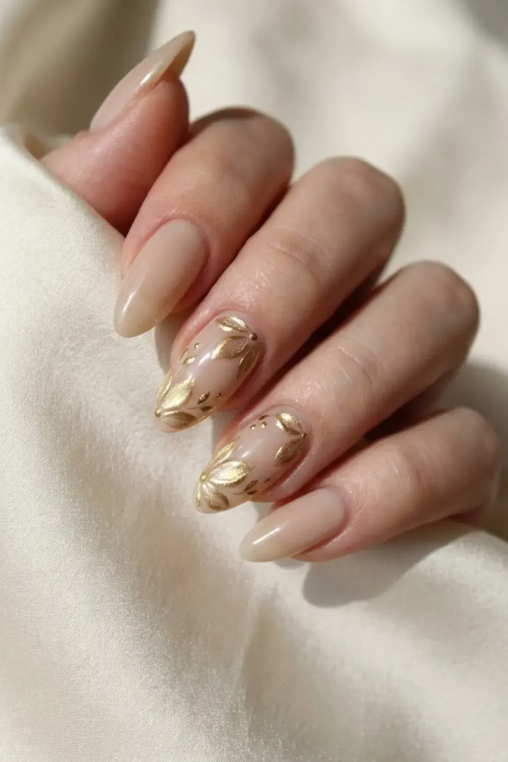 Sheer neutral nails with delicate gold cat eye chrome floral art