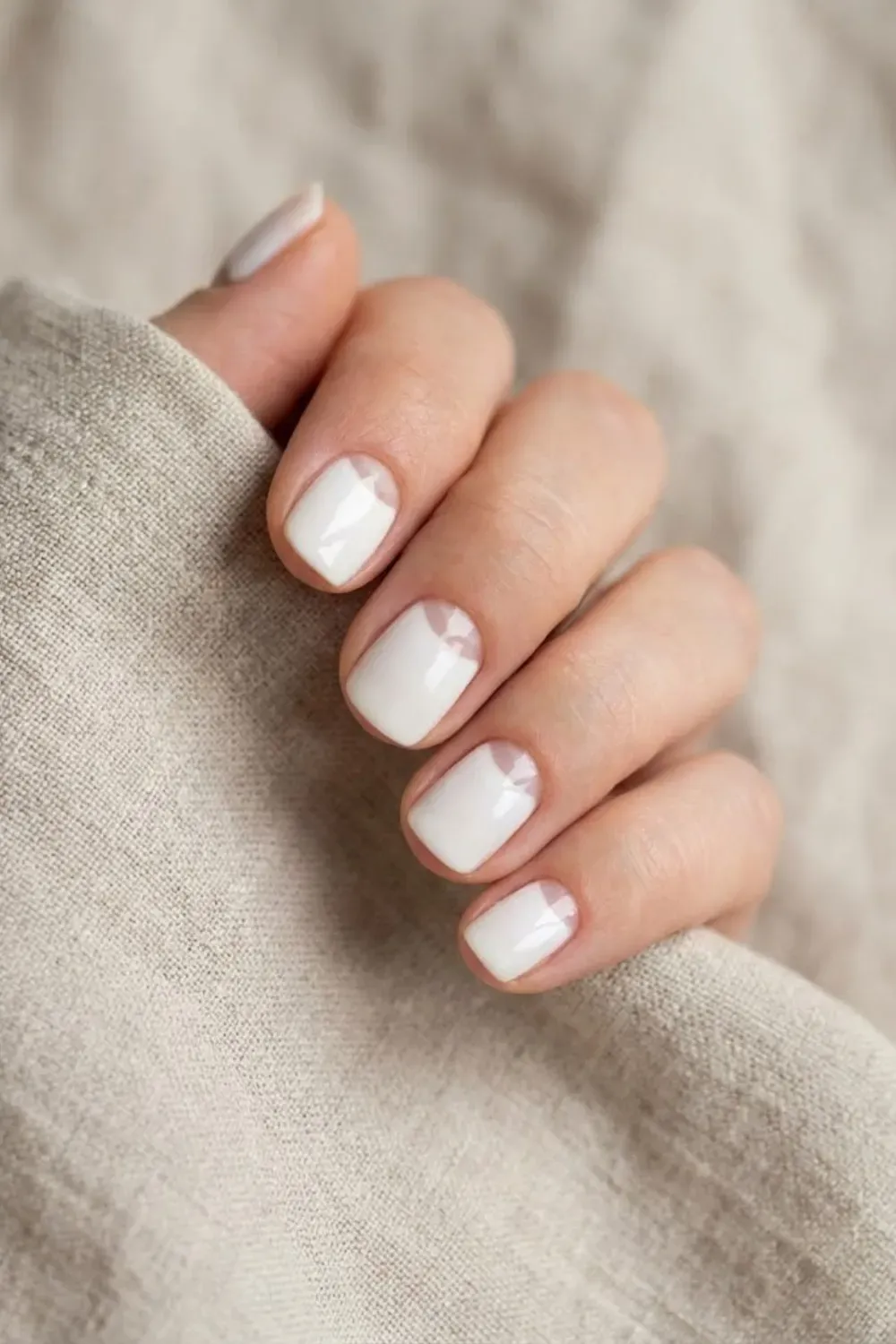 Negative Space Half-Moon White - Short nails with a negative space half-moon cuticle design and crisp white polish on the rest of the nail.