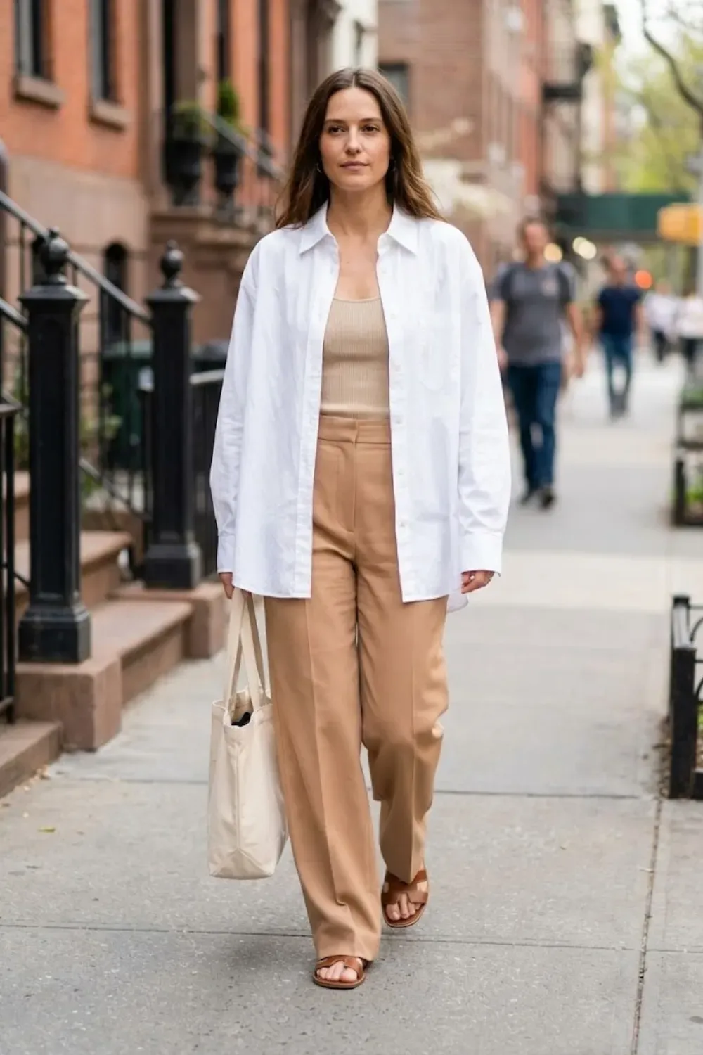 Relaxed oversized white button-down shirt paired with neutral shorts minimalist style.