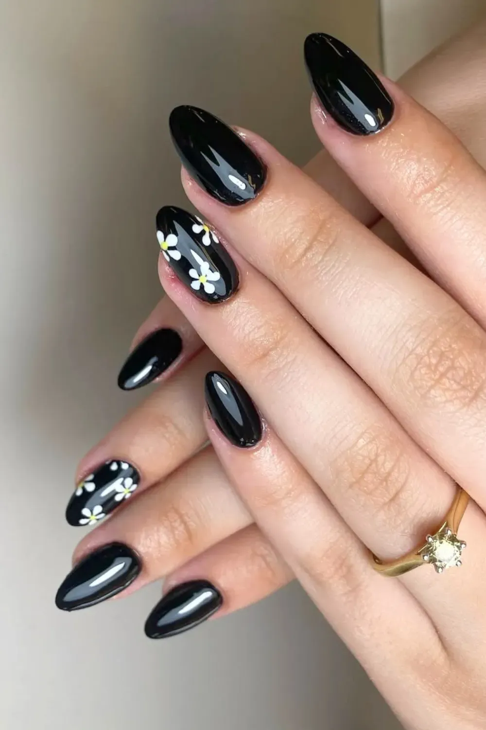 Dainty White Flowers on Black	Glossy black almond nails with small white flowers
