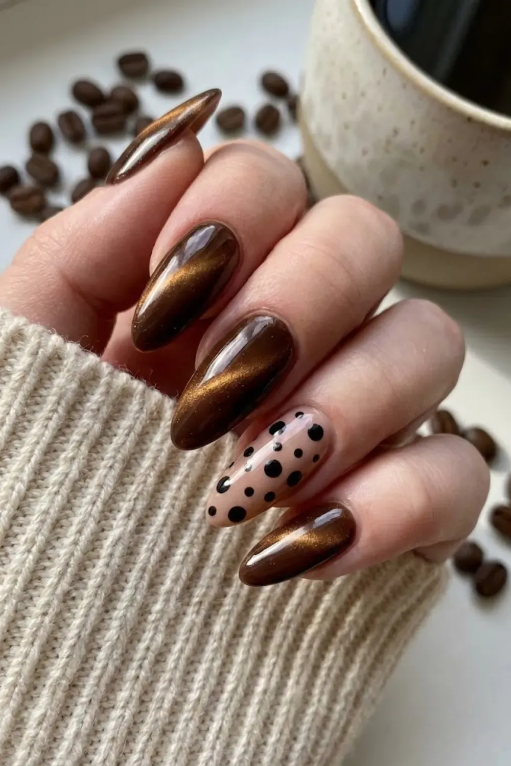 Brown cat eye nails with playful black polka dot nail art