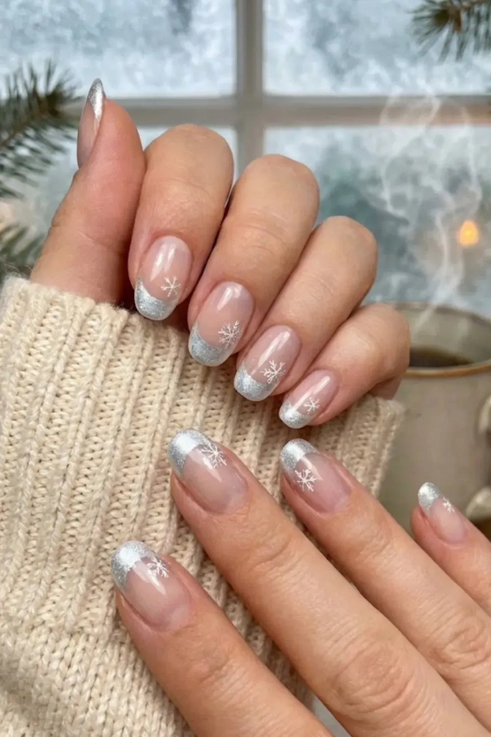 Silver Glitter Snowflake Nails — oval nails with sparkling silver glitter tips and white snowflake art.