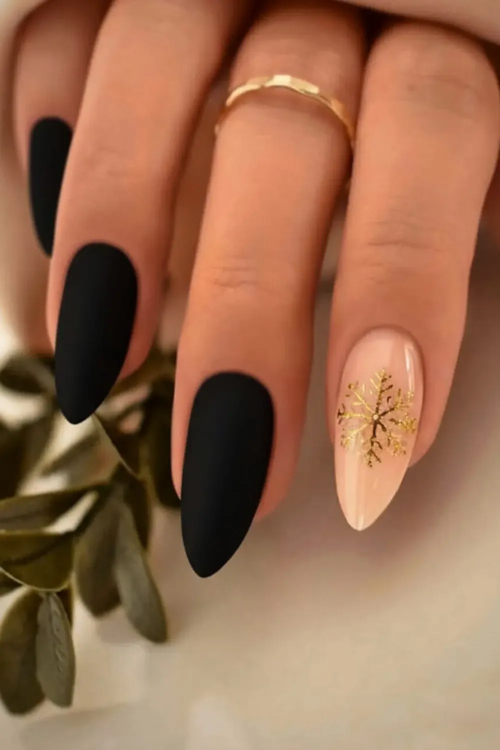 Elegant Winter Snowflake	Matte black nails with nude nail and gold snowflake