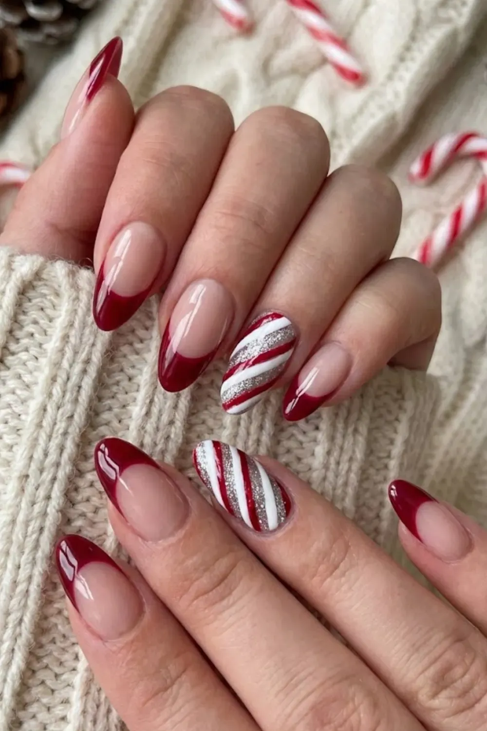 Elegant Candy Cane Tips — oval nails with deep red tips and diagonal silver glitter candy cane stripes.