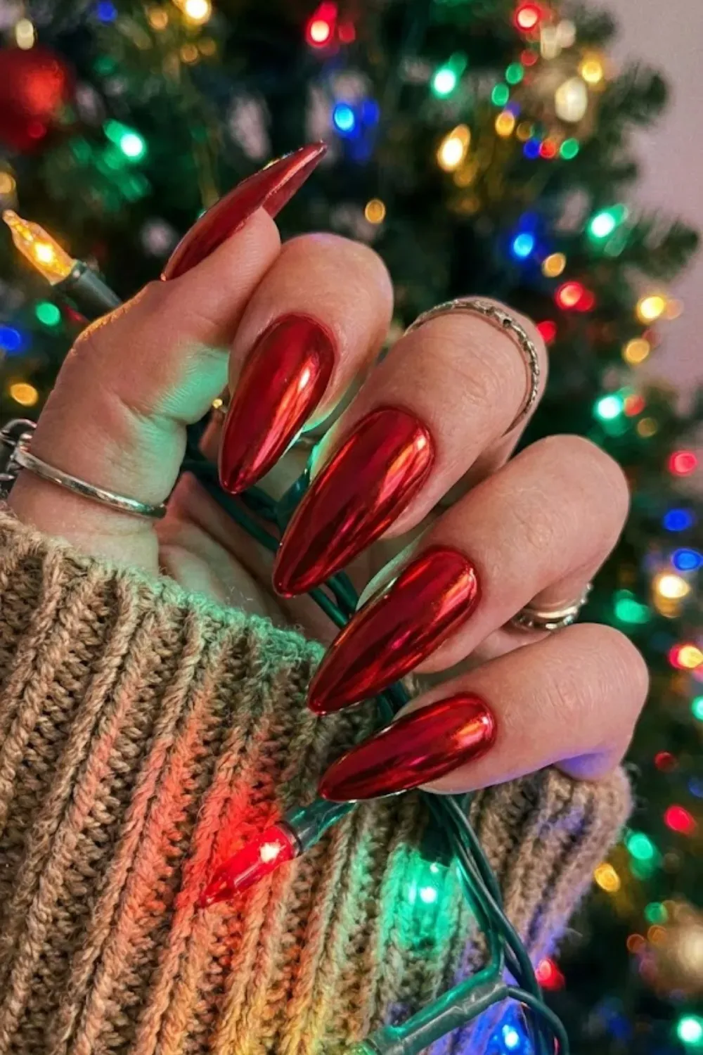 Striking Red Chrome Long Almond Nails - High-shine red chrome finish on long almond nails, a trending holiday manicure style for 2025.