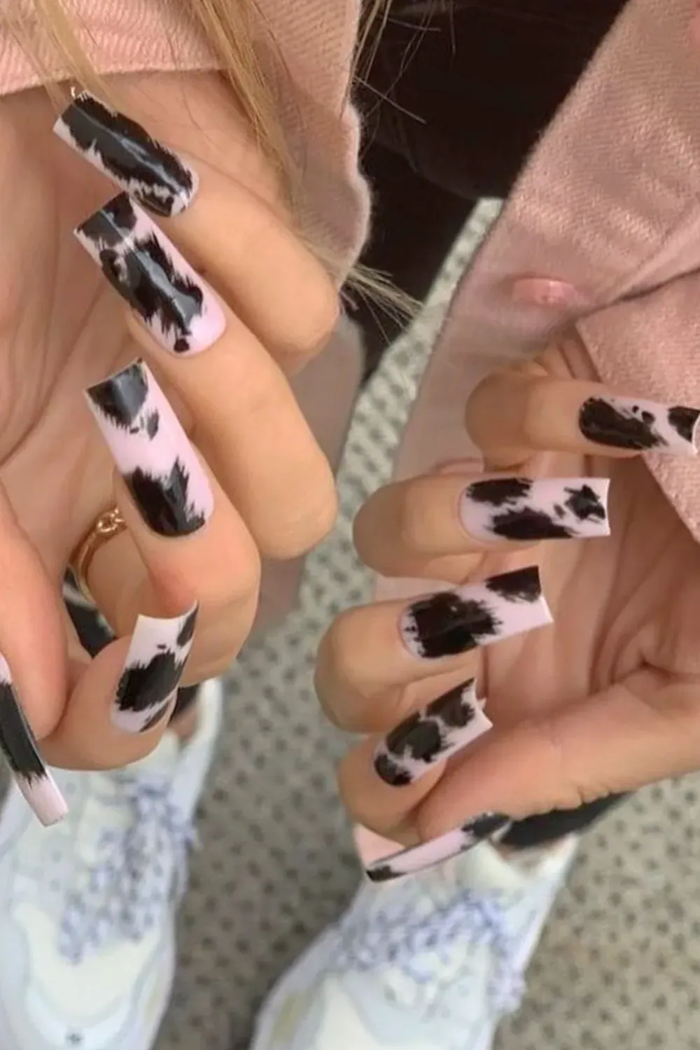 Trendy Pink Cow Print	Long square pink nails with black cow print design