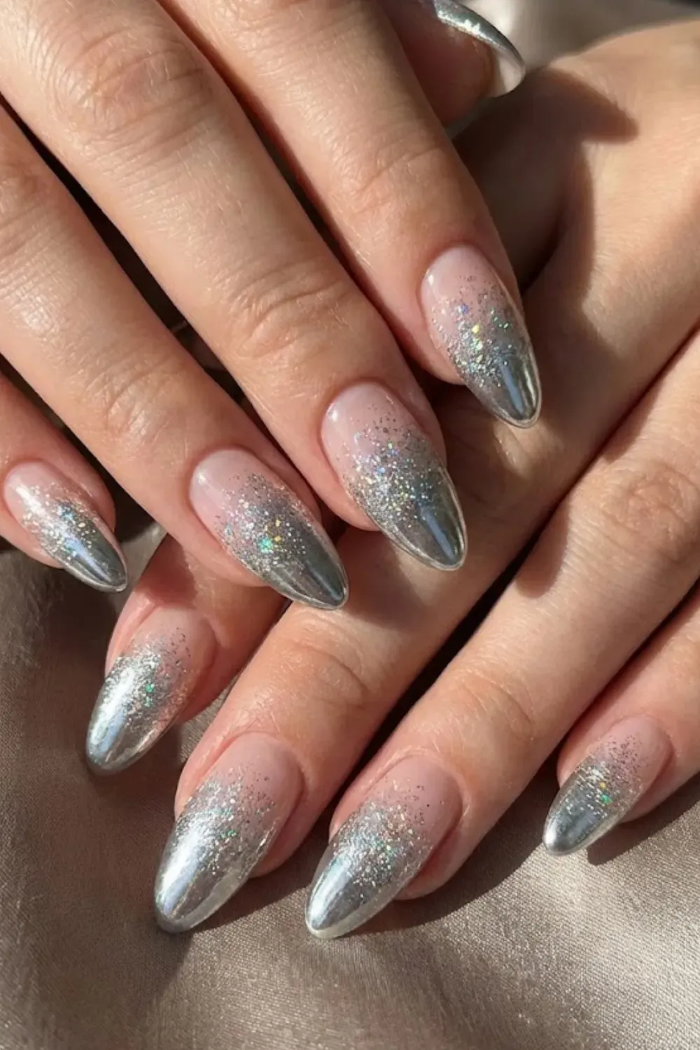 Silver Chrome Ombre Nails — almond nails featuring a metallic silver chrome gradient tip fading to nude.