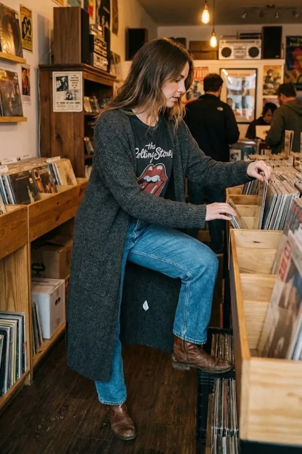 Long Grey Cardigan & Graphic Tee - Edgy casual look with a long charcoal cardigan over a graphic Rolling Stones tee and jeans in a record store.