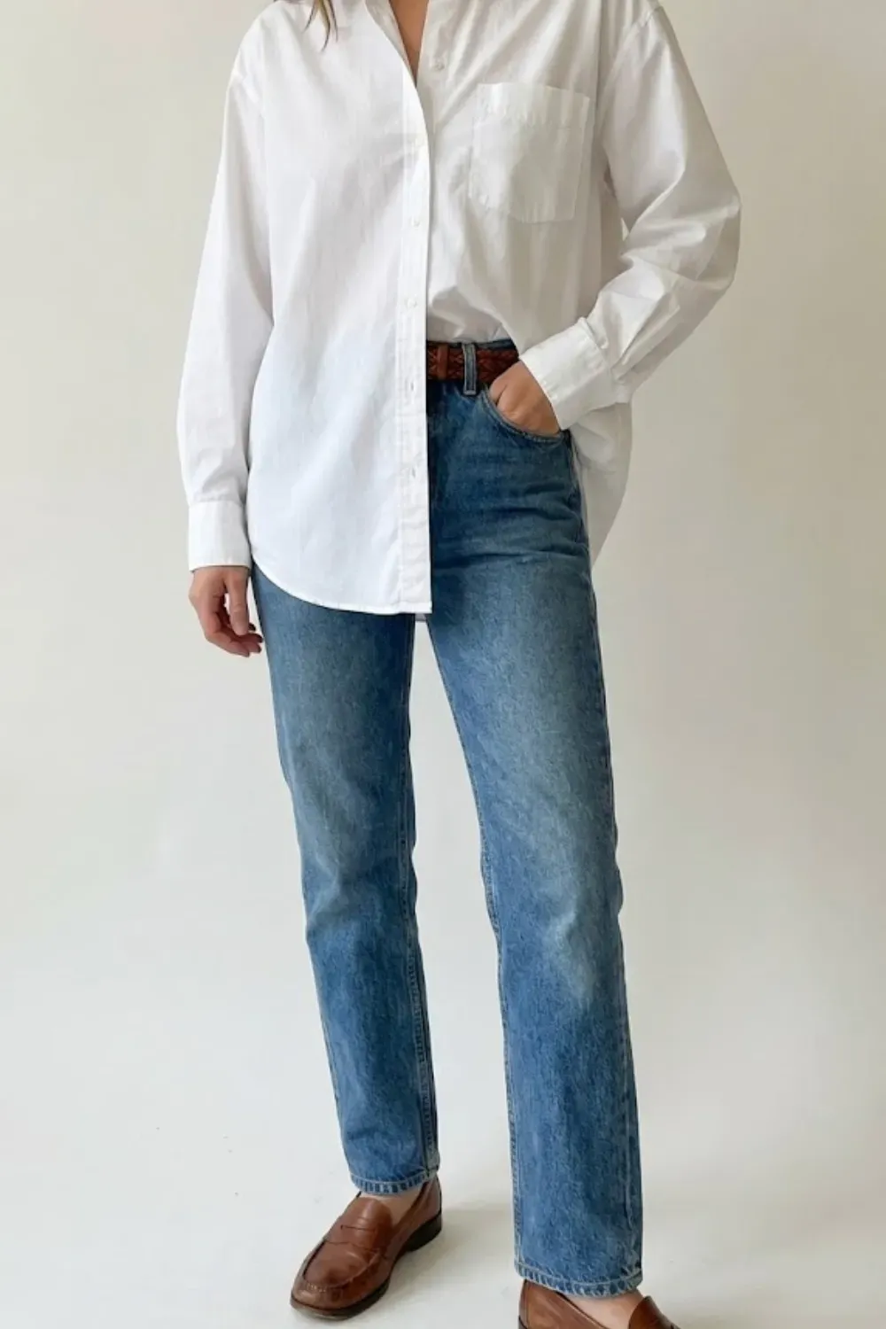 Crisp White Shirt & Classic Denim – timeless casual outfit with a white button-down shirt tucked into blue jeans with loafers.