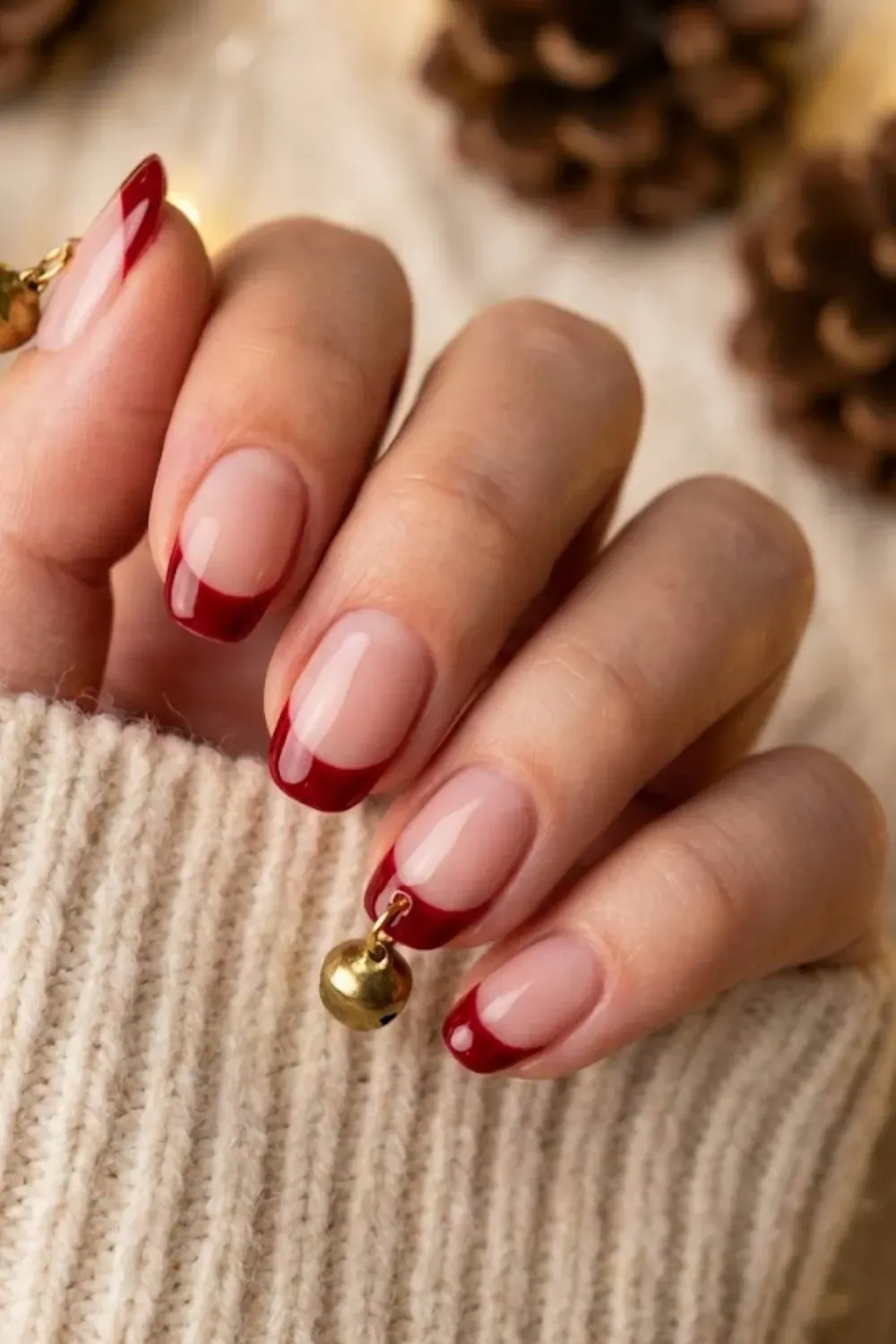 Jingle Bell Red Nails — oval nails with red French tips and real miniature gold jingle bell charms.