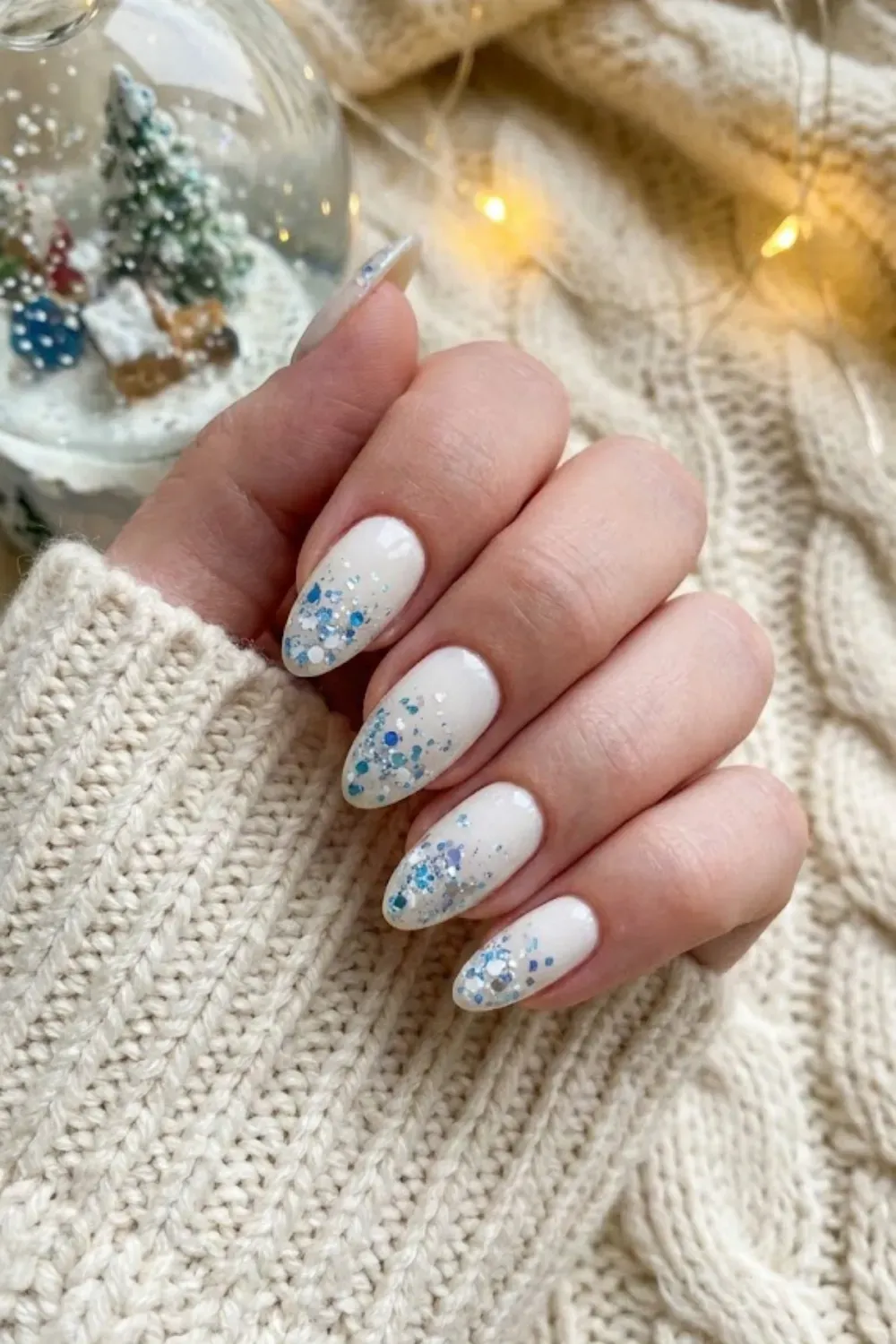Icy Blue and Silver Glitter Gradient Nails - Milky white almond nails featuring a chunky blue and silver glitter gradient for a winter wonderland look.