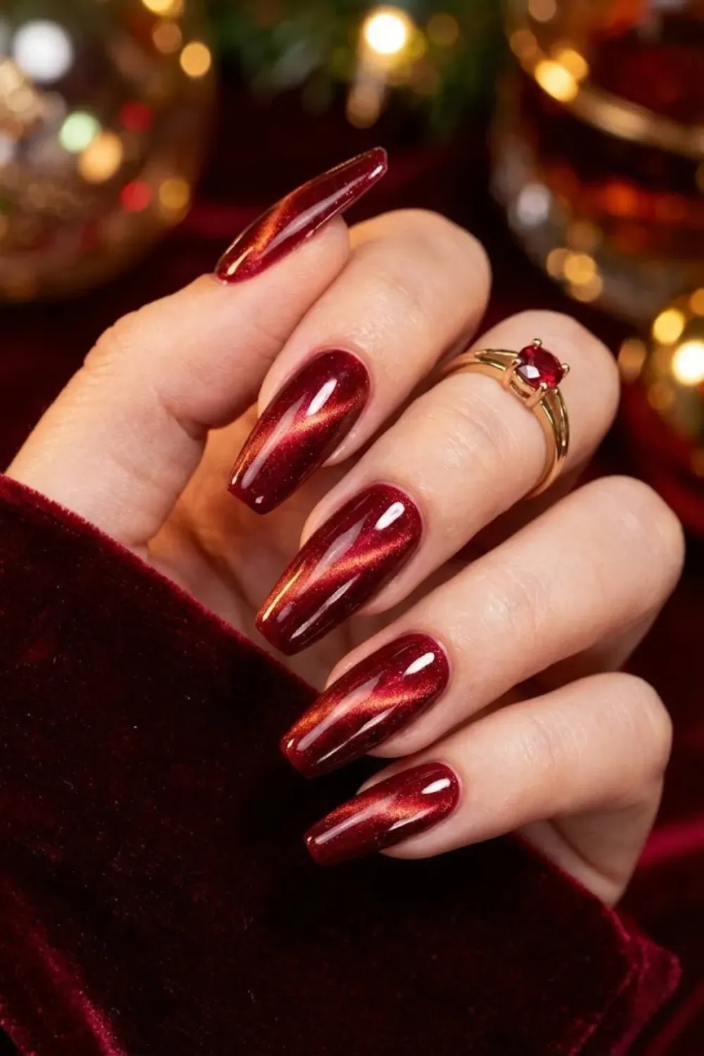 Vibrant ruby red cat eye nails with sharp glowing magnetic line