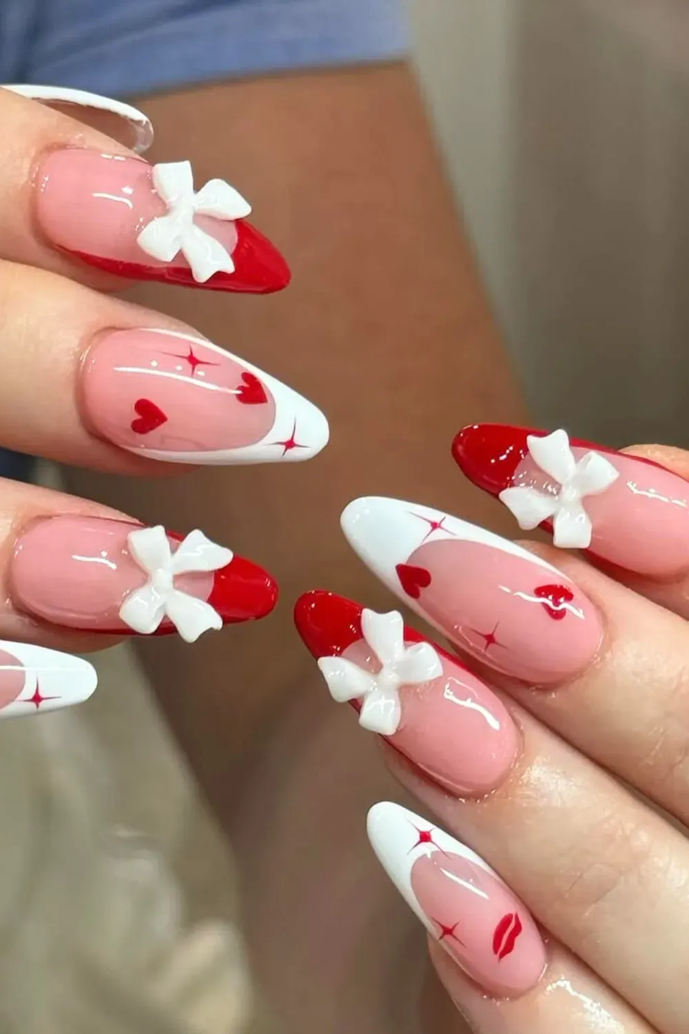 Coquette Red French Tips with 3D White Bows – Red french tip almond nails adorned with 3D white bows, stars, and hearts.